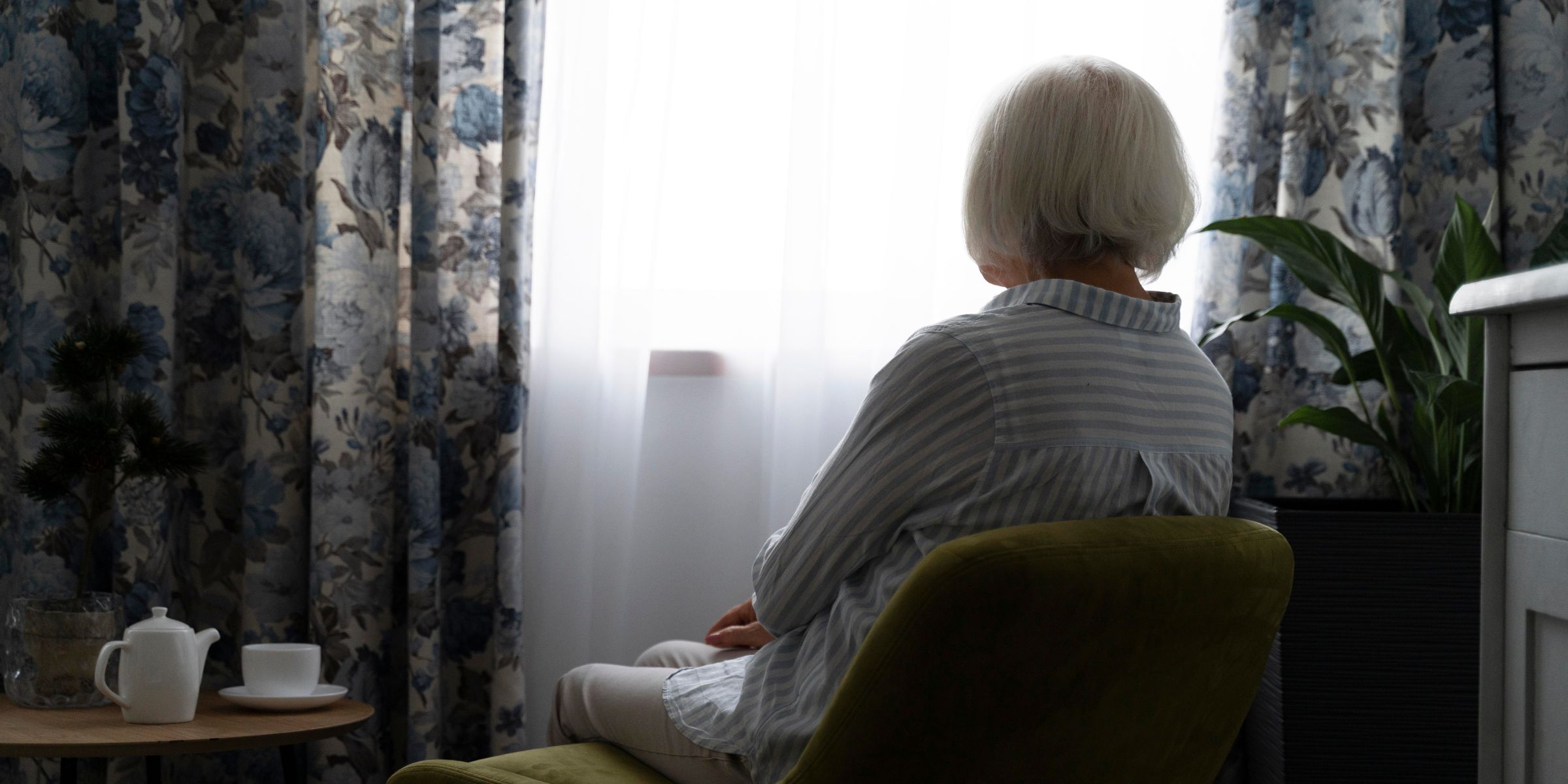 Une femme âgée assise près d'une fenêtre | Source : Freepik