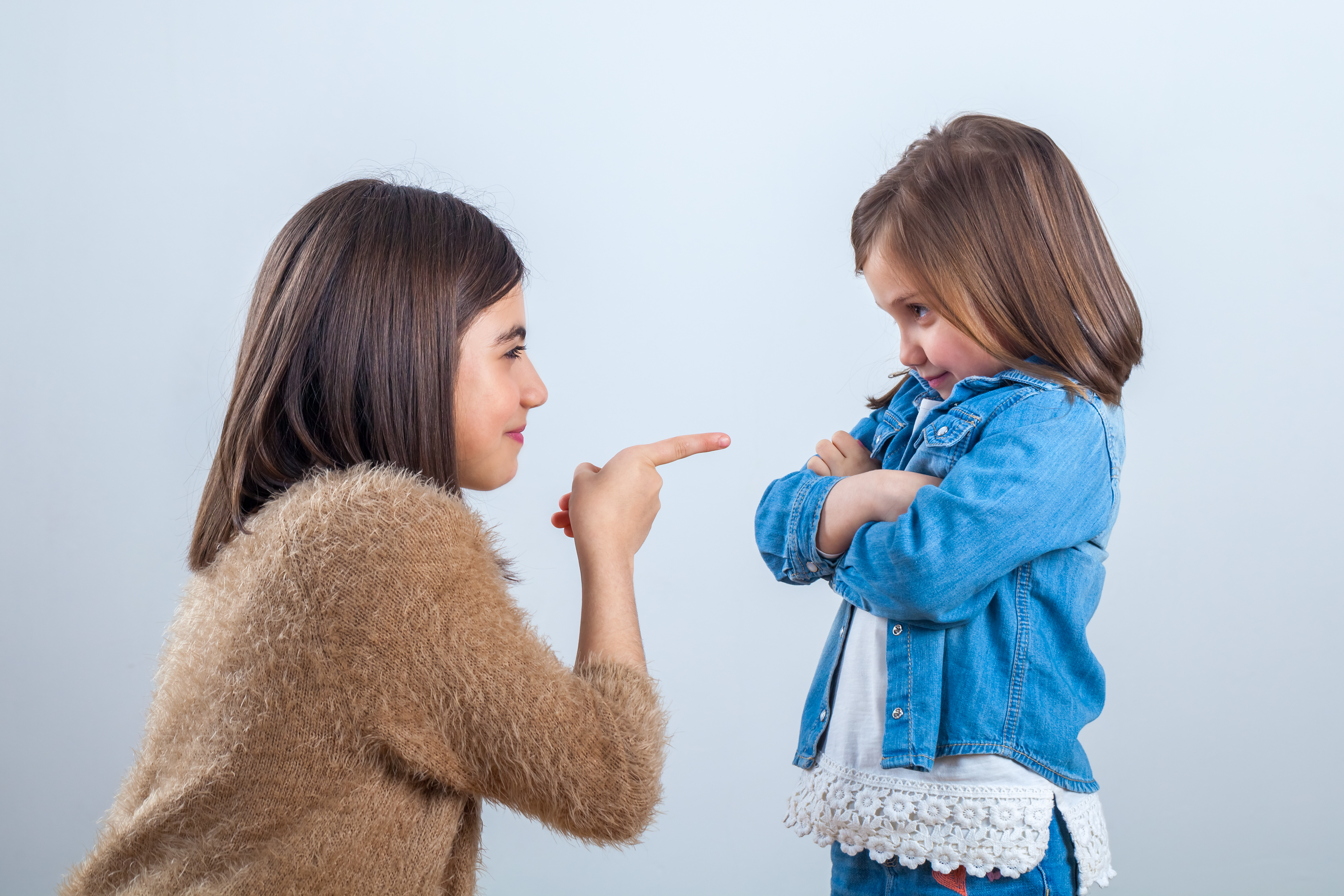 La sœur aînée fait une remarque à la plus jeune avec un doigt | Source : Getty Images