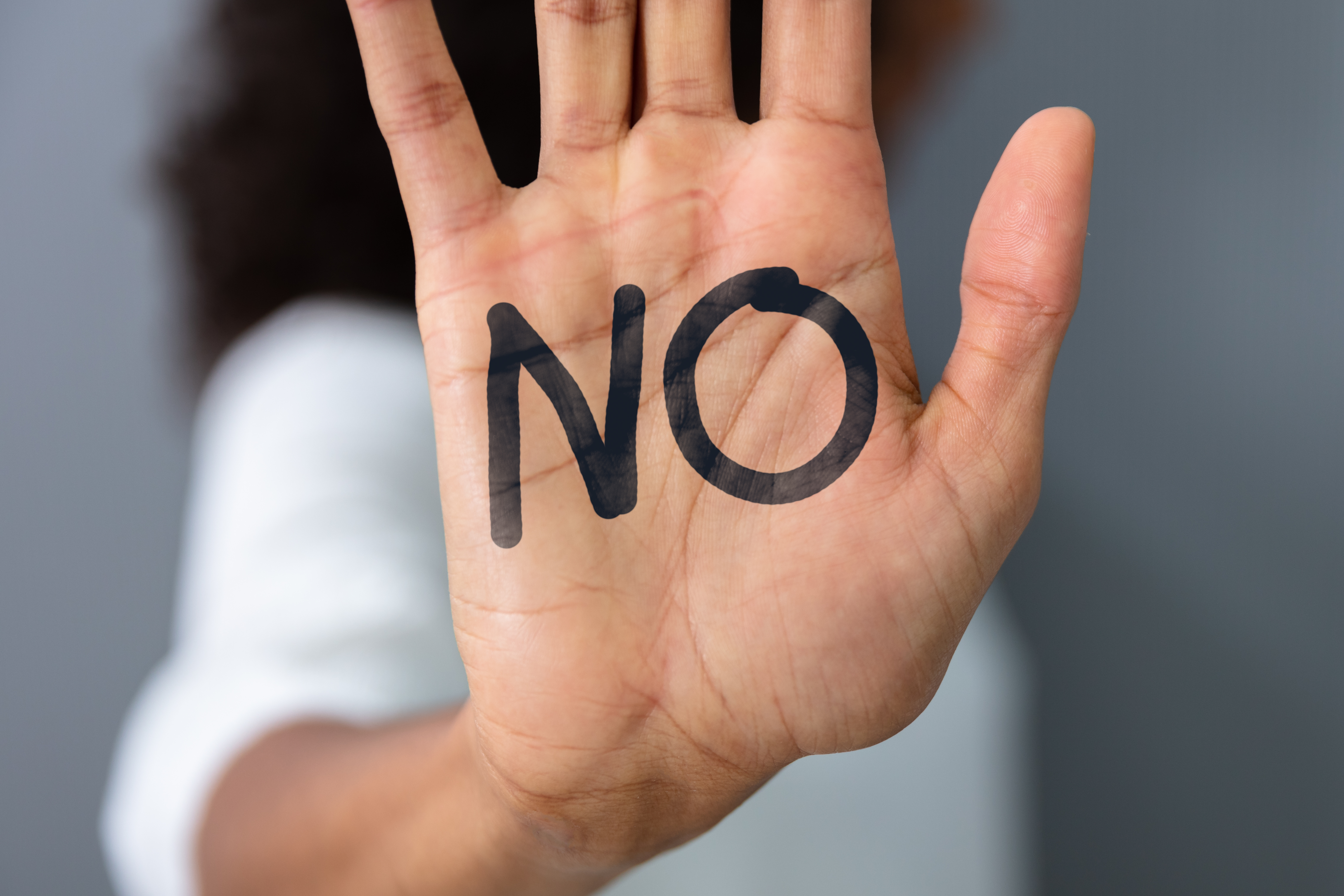 La main levée d'une femme avec le texte "Non" | Source : Shutterstock