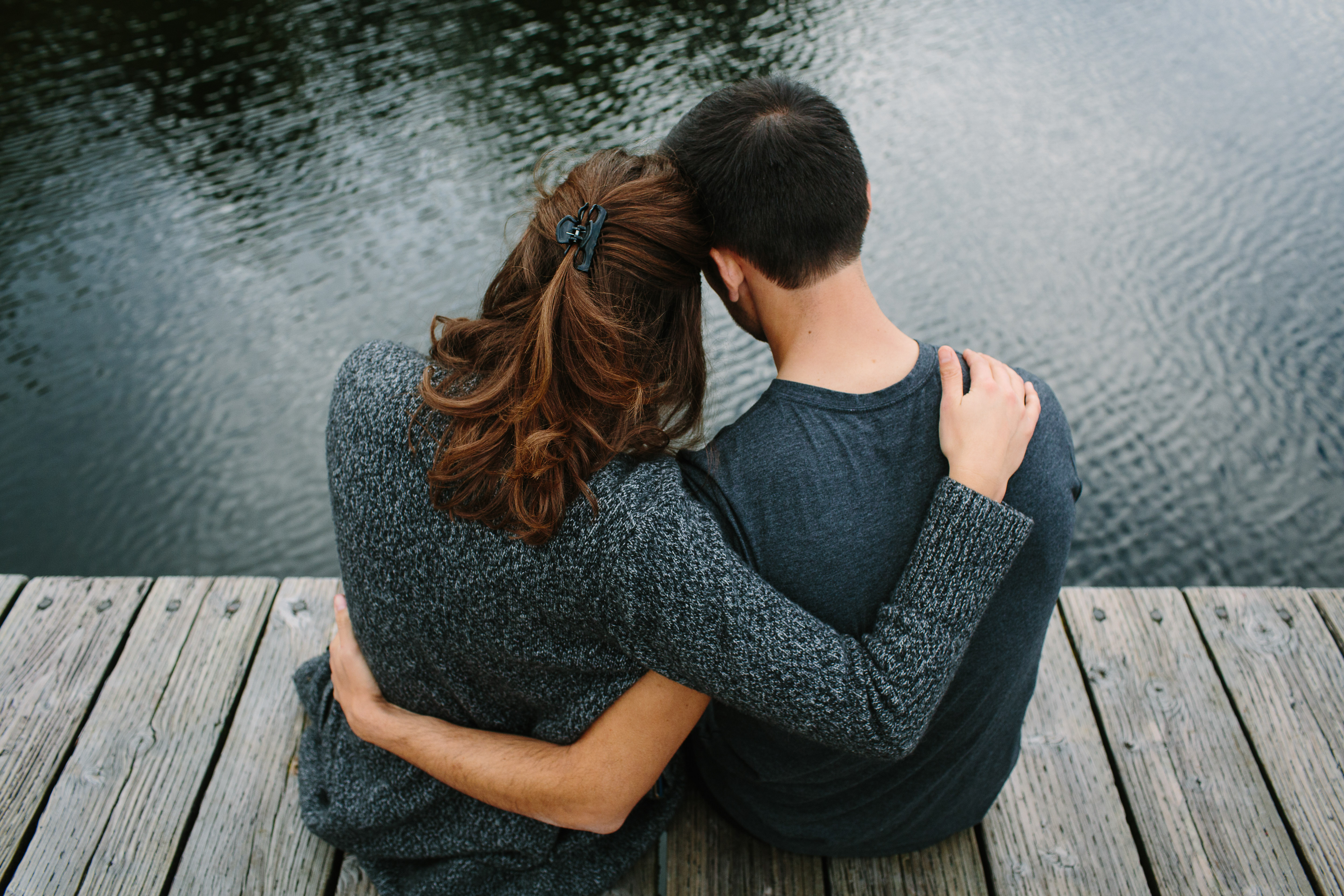 Photo d'un couple se faisant des câlins sur la jetée | Source : Shutterstock