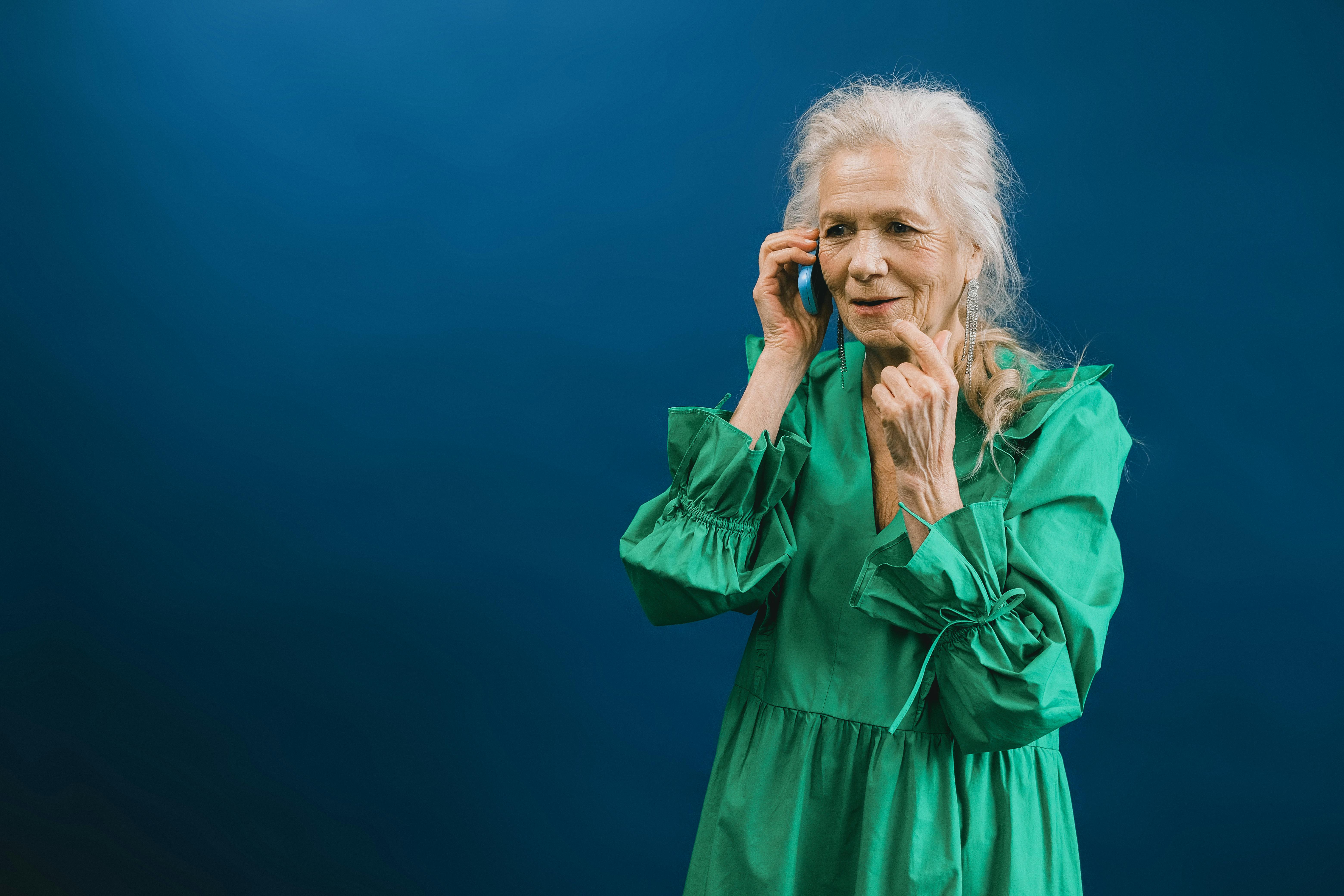 Une femme âgée souriante sur son téléphone | Source : Pexels