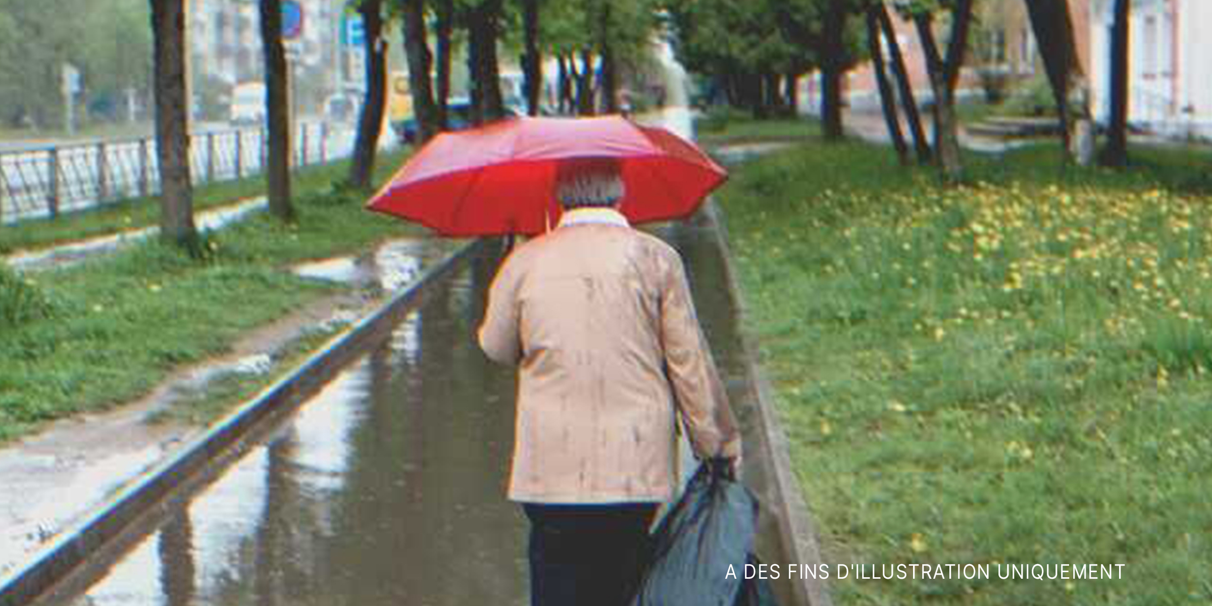 Une femme âgée marchant sous la pluie | Source : Shutterstock