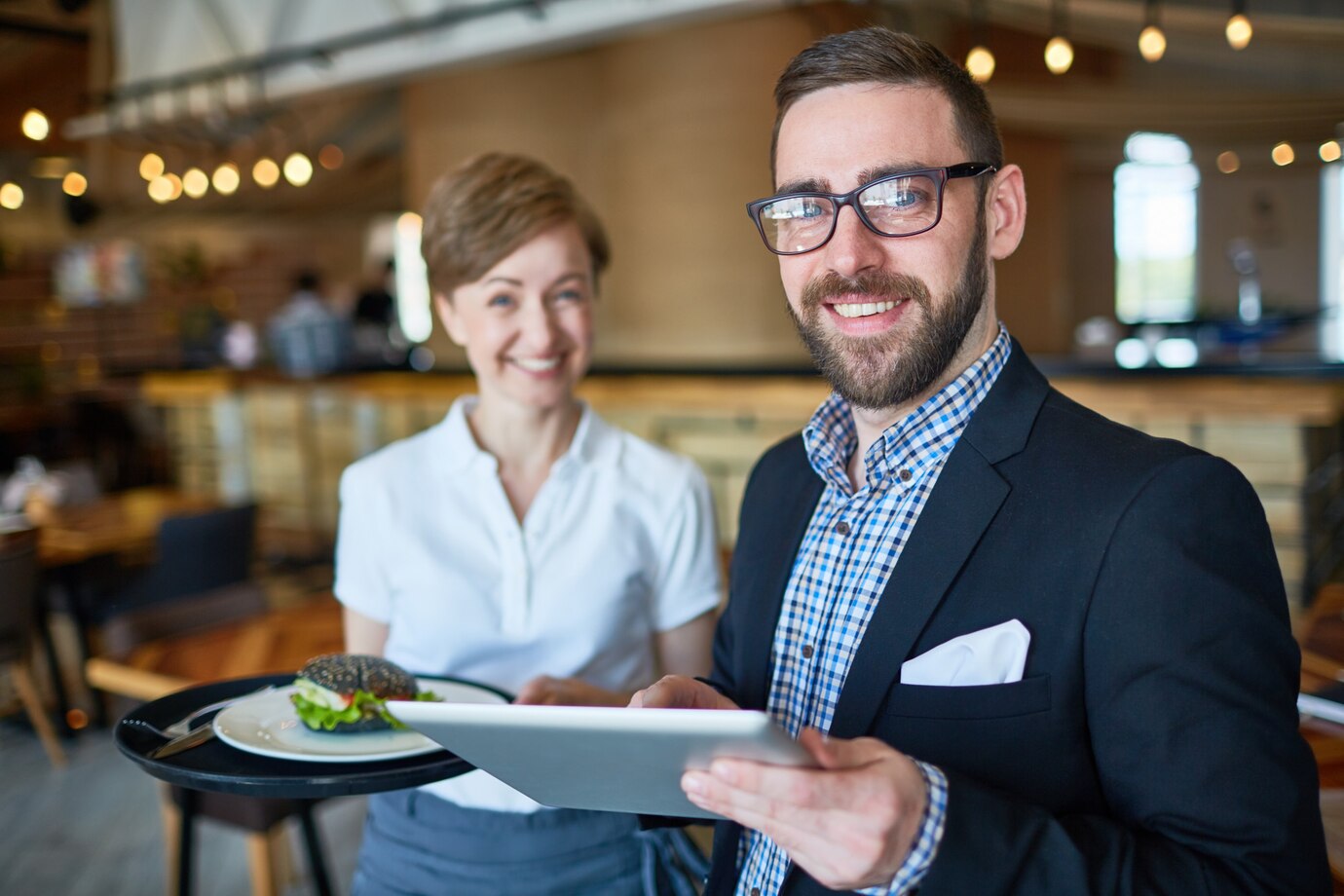 Un manager et une serveuse souriants | Source : Freepik