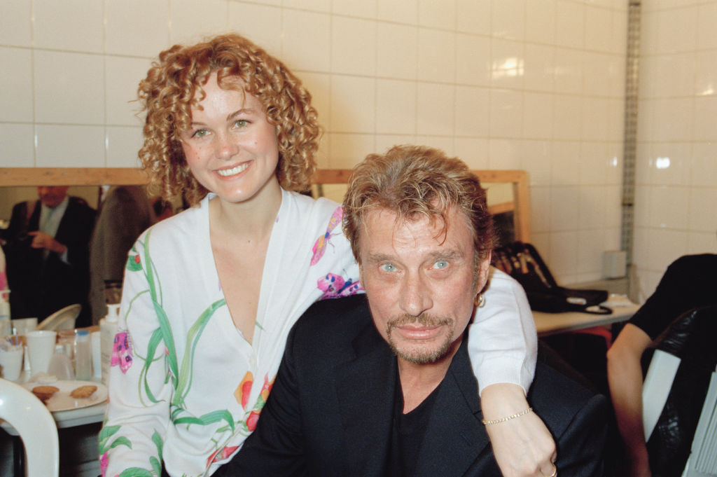 Laeticia Hallyday et son mari Johnny Hallyday posant dans les coulisses, Paris, le 19 octobre 1997 | Source : Getty Images