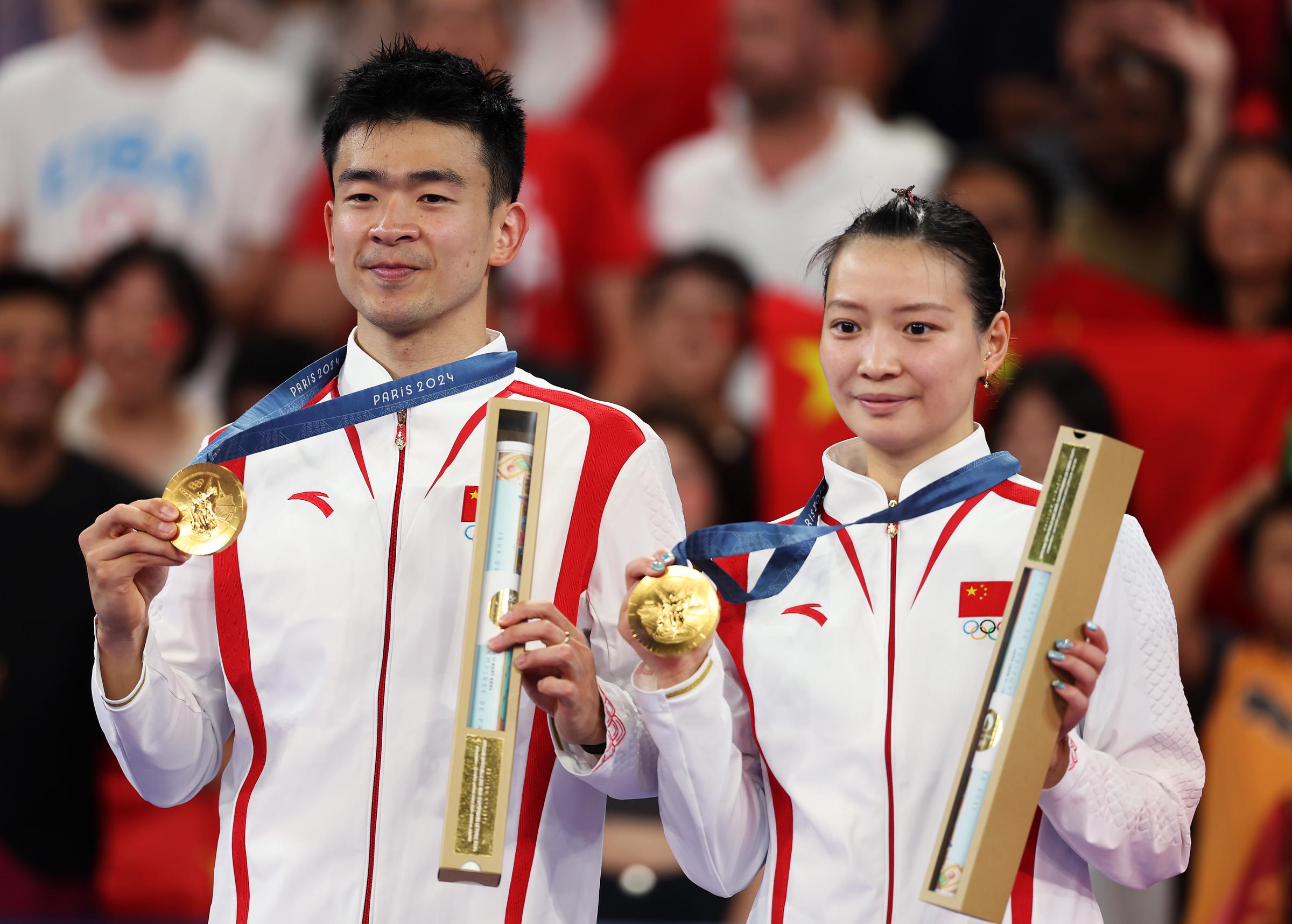 Zheng Siwei et Huang Ya Qiong posant avec leurs médailles d'or lors de la cérémonie de remise des médailles du double mixte de badminton à Paris, France, le 2 août 2024 | Source : Getty Images