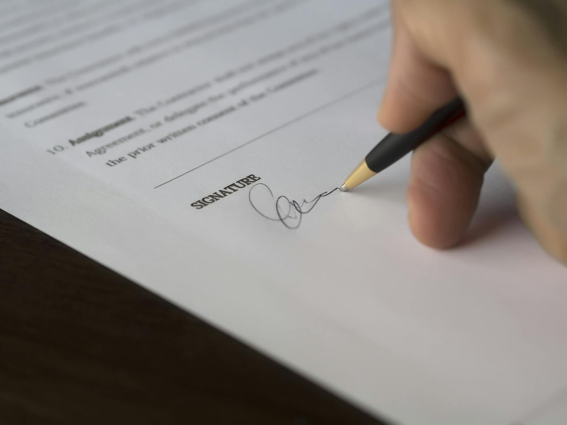 Une personne signant un document | Source : Pexels