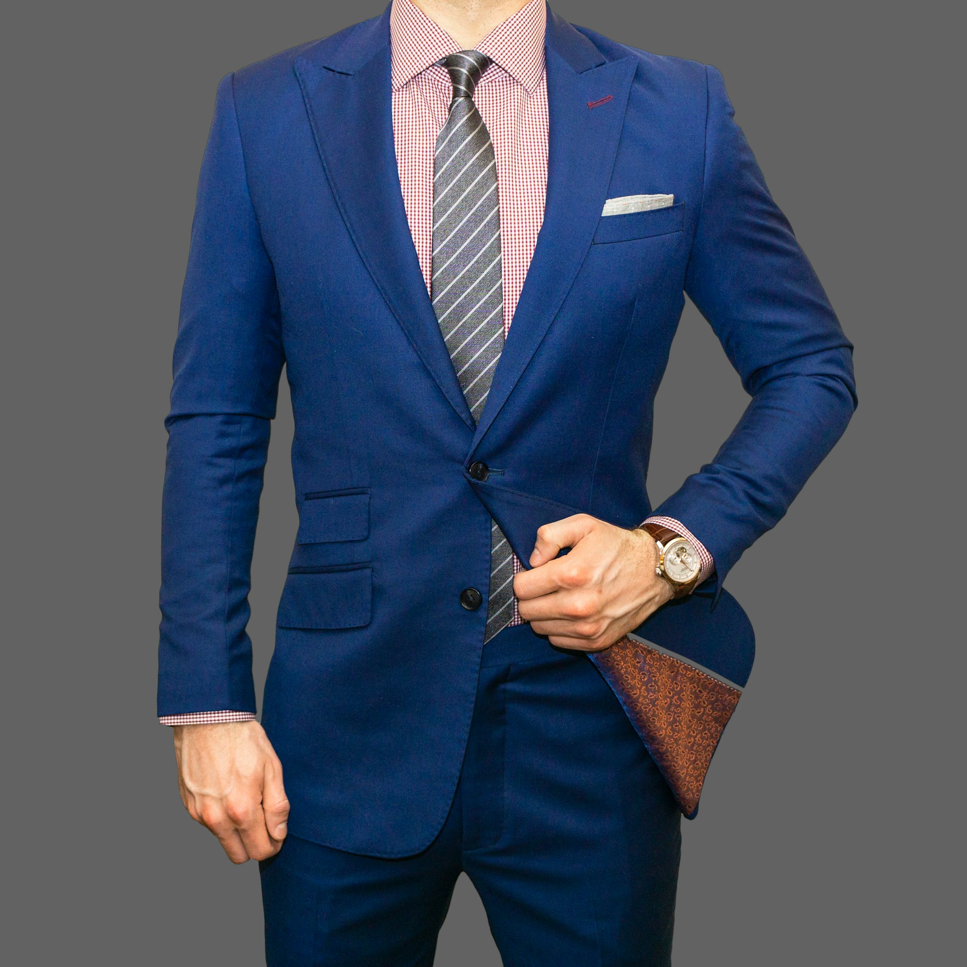 Un homme portant un costume et une cravate bleu marine à rayures | Source : Unsplash