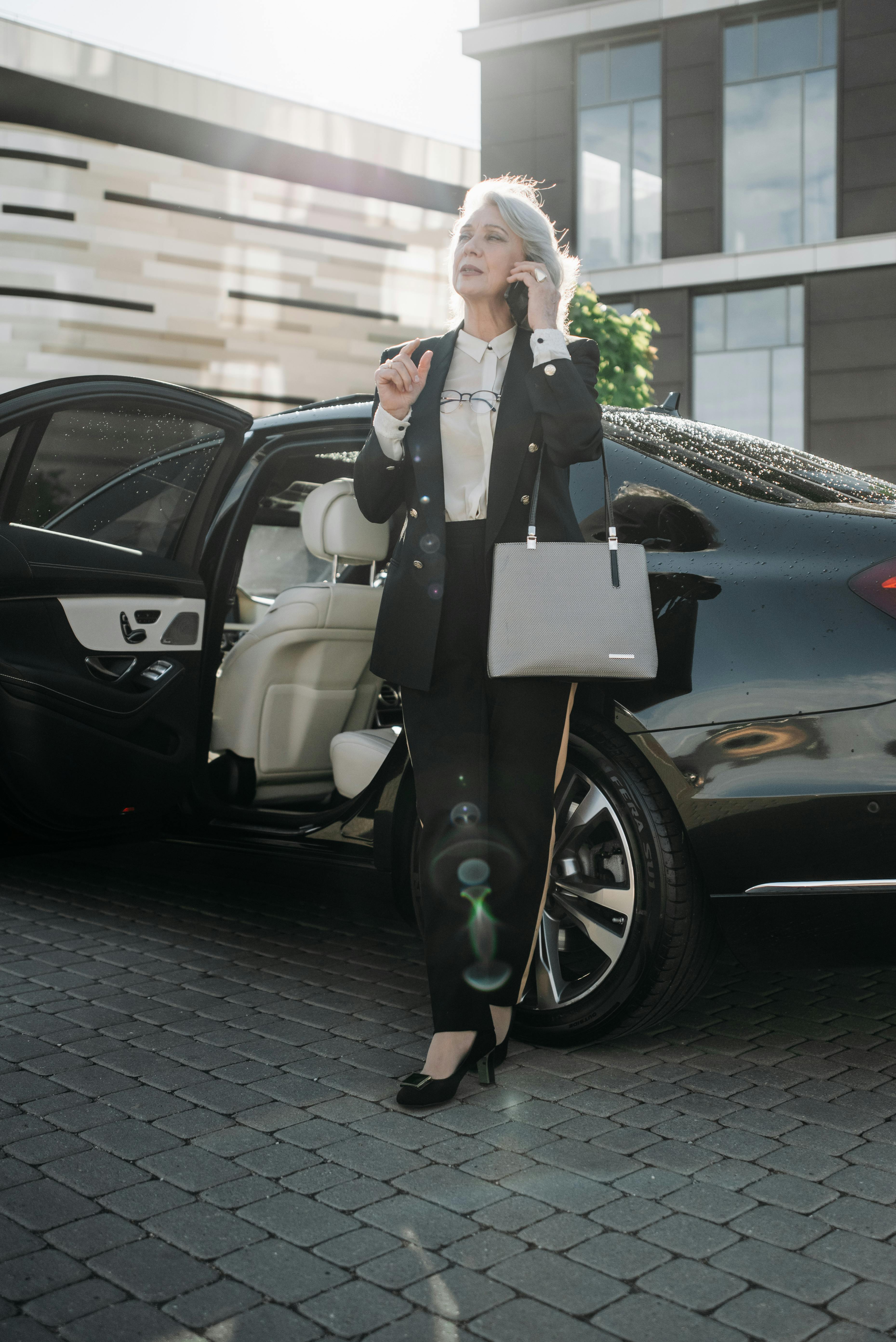 Une femme se tenant à côté d'une voiture coûteuse | Source : Pexels