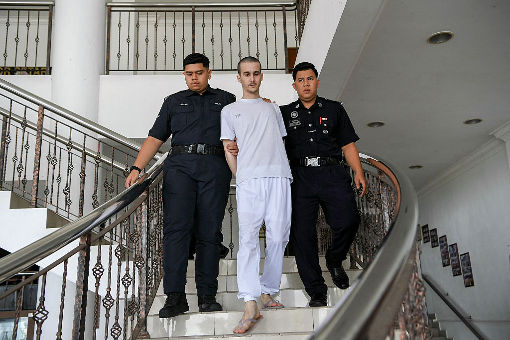 GettyImaLe ressortissant français Tom Felix, accusé de possession et de trafic de cannabis, est escorté par des officiers de la police royale de Malaisie à la Haute Cour d'Alor Setar le 16 juin 2025. | Source : Getty Images