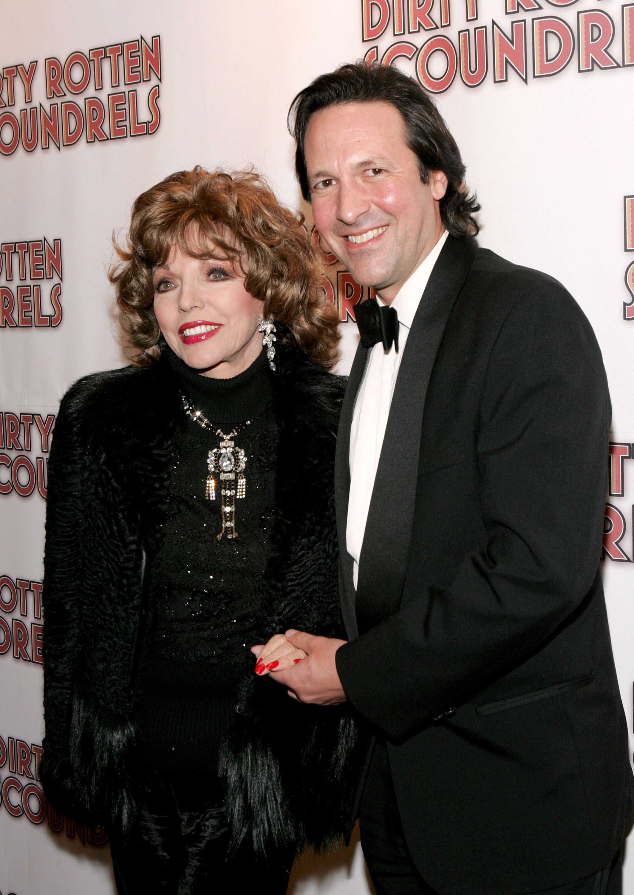 Joan Collins, portant du vernis à ongles rouge, avec son mari Percy Gibson le 3 mars 2005, à New York | Source : Getty Images
