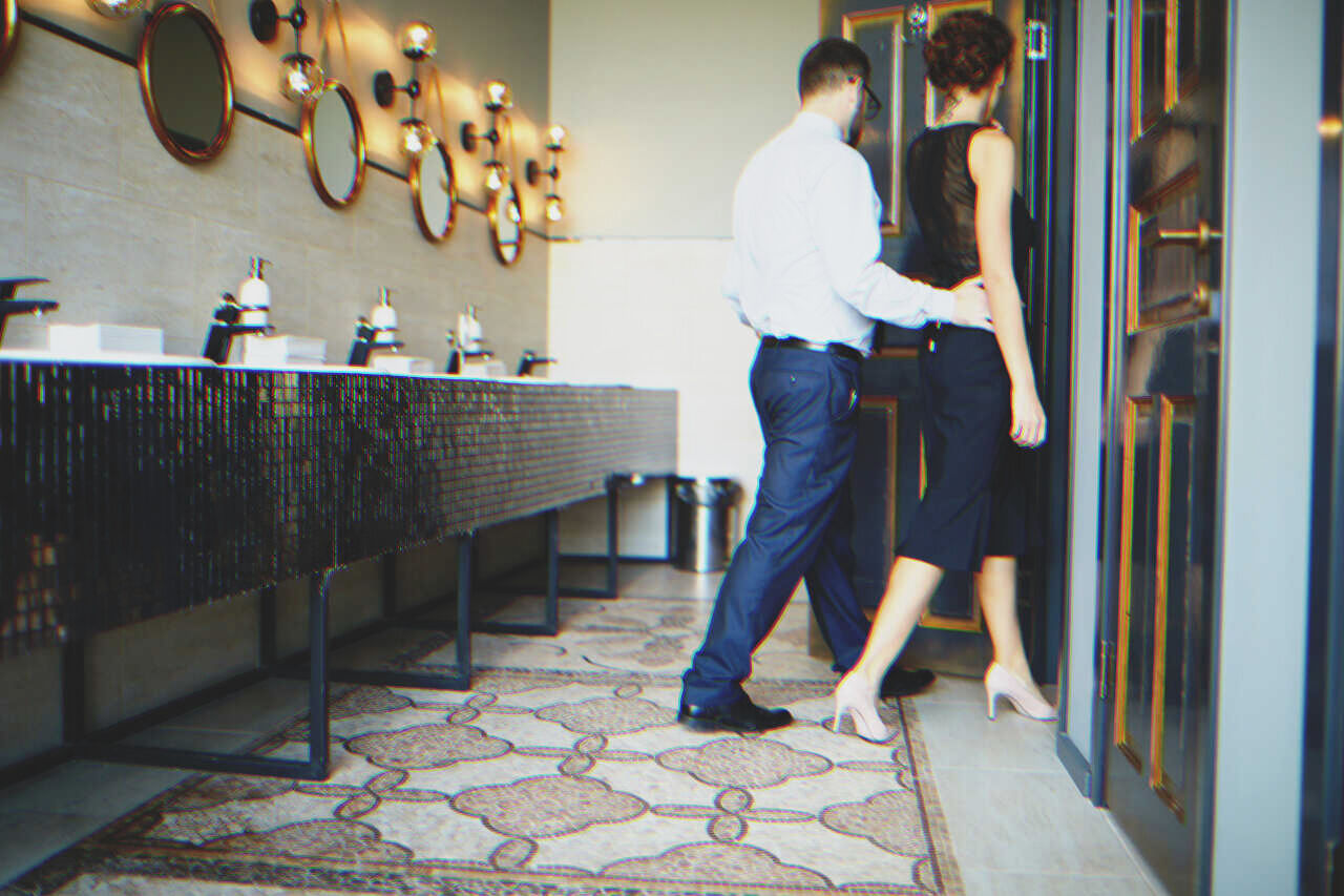 Casal entra em cubículo de banheiro | Fonte: Shutterstock