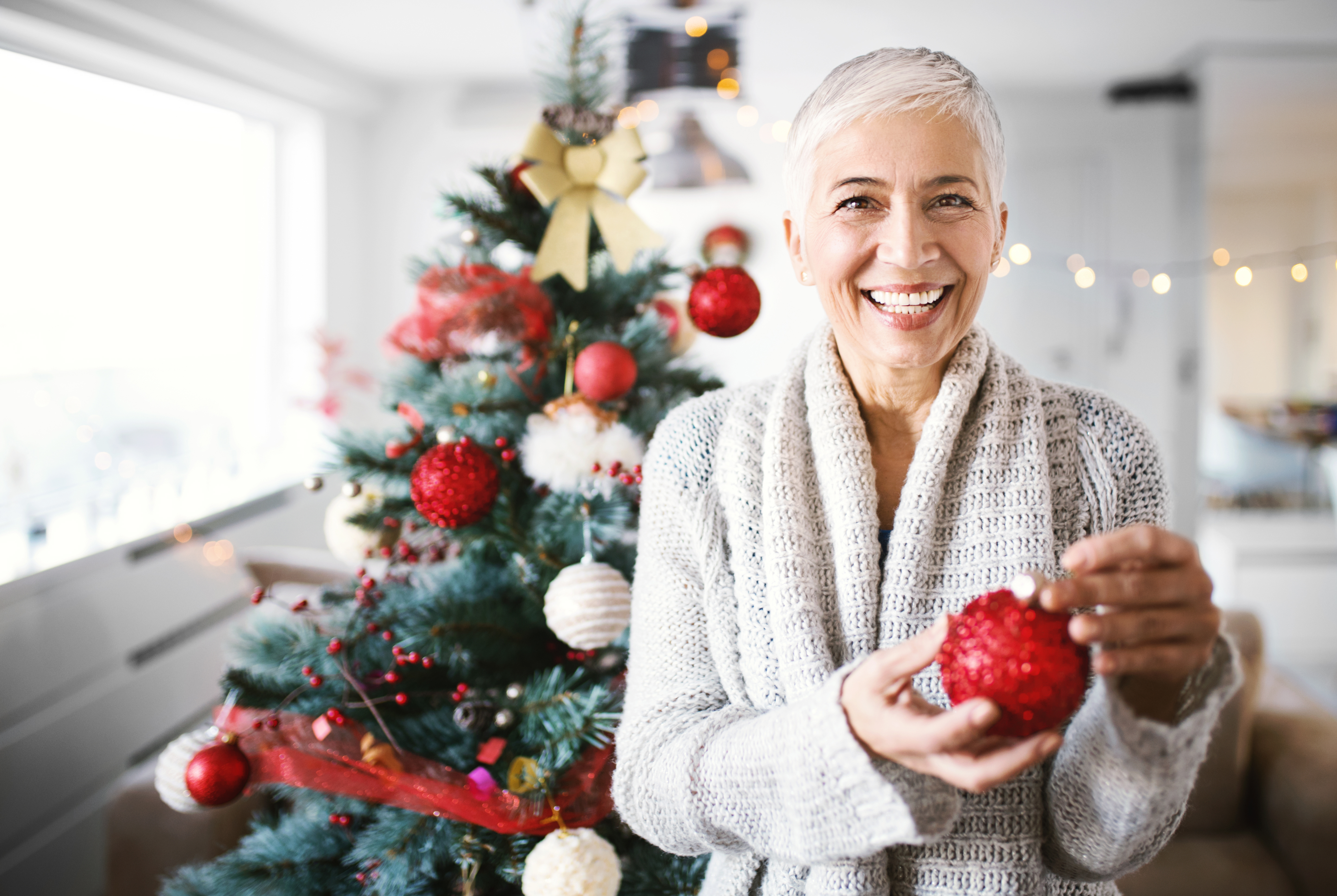 Une femme âgée décore son arbre de Noël. | Source : Getty Images