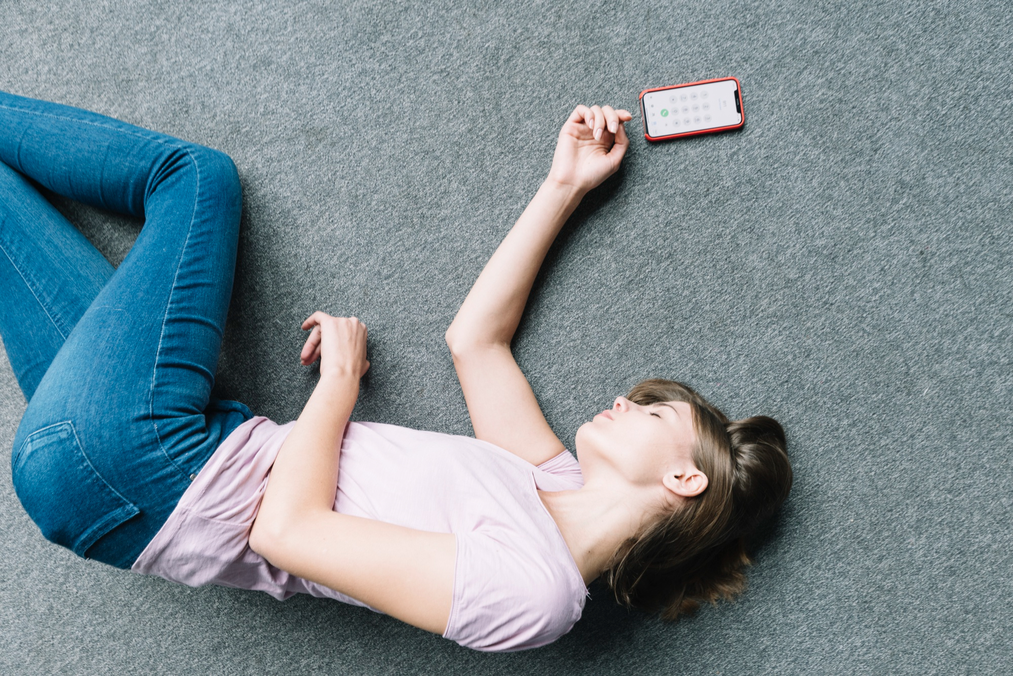 Une femme inconsciente allongée à côté d'un téléphone | Source : Freepik