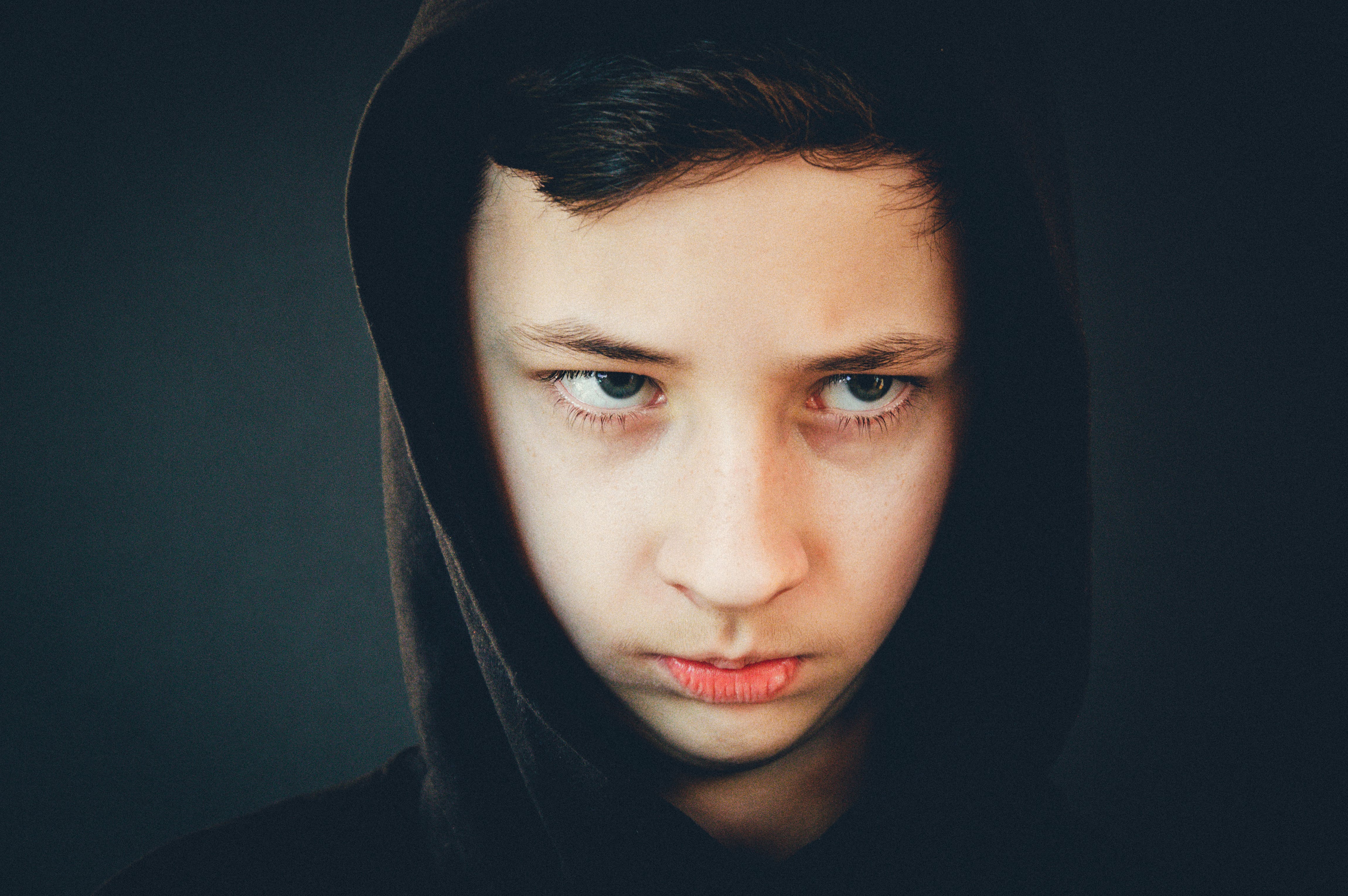 Un garçon contrarié qui porte un sweat à capuche et qui a l'air sombre | Source : Pexels