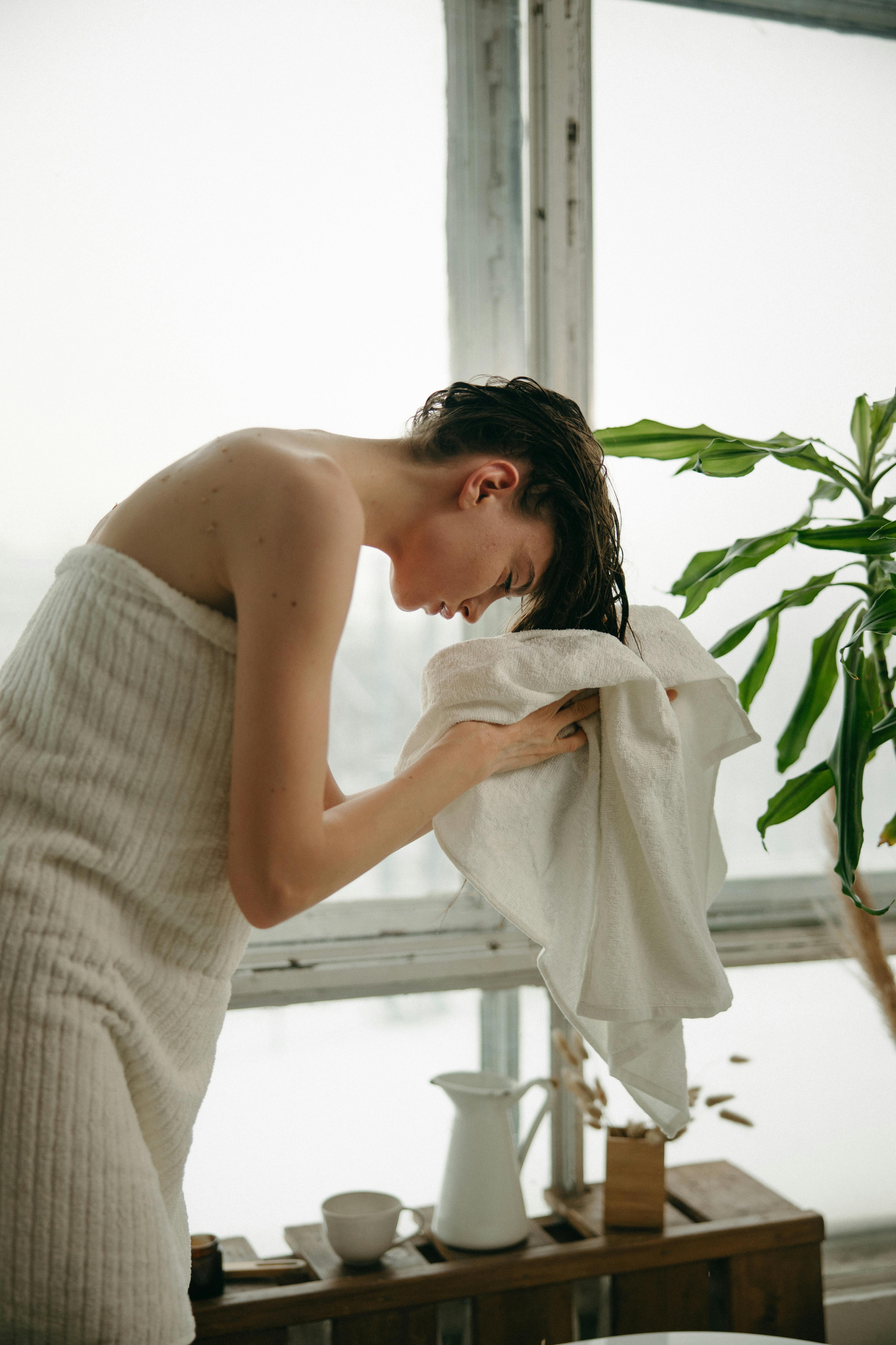 Une femme se séchant les cheveux avec une serviette après la douche | Source : Pexels