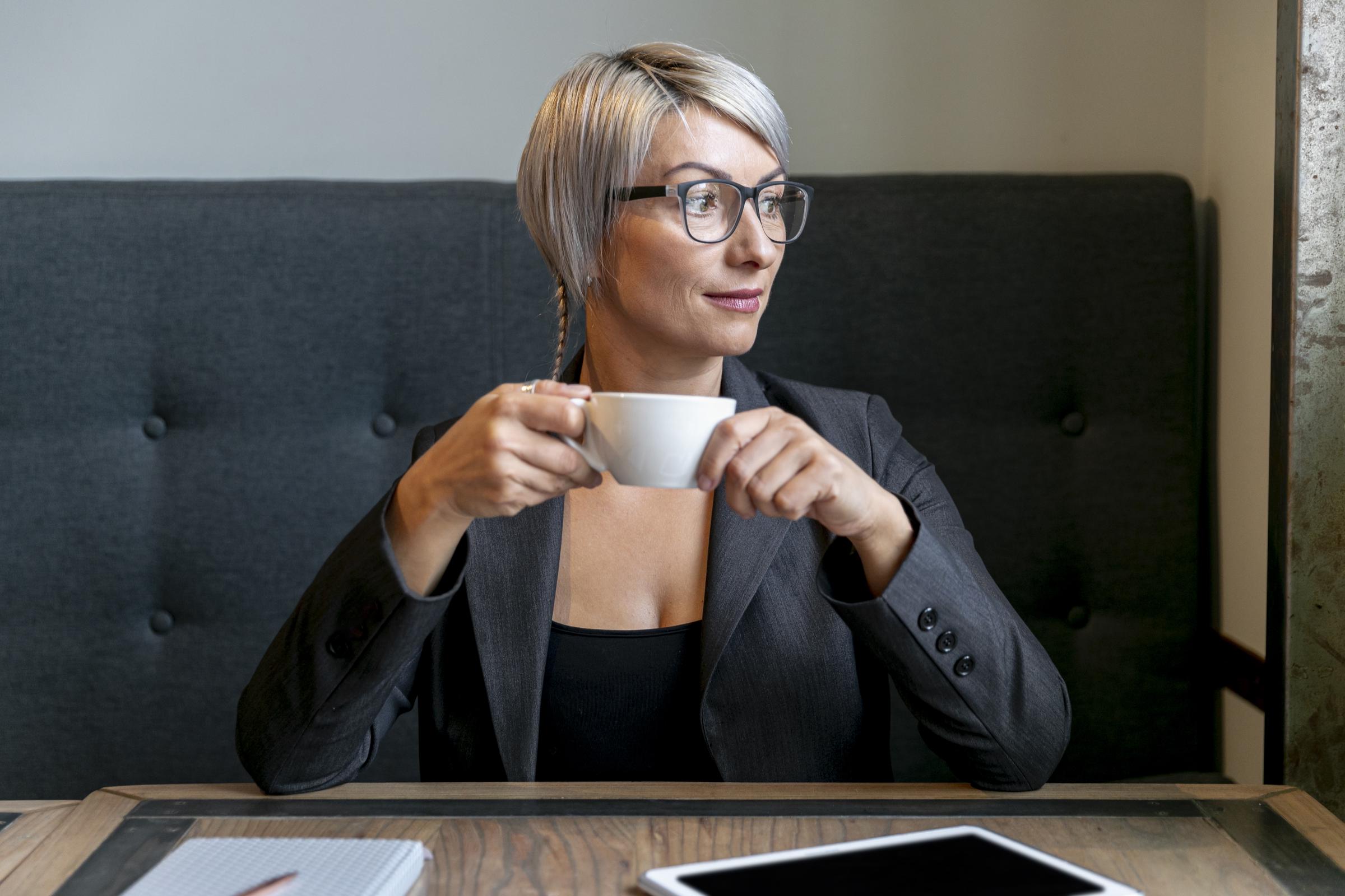 Une femme joyeuse tenant une tasse de café | Source : Freepik