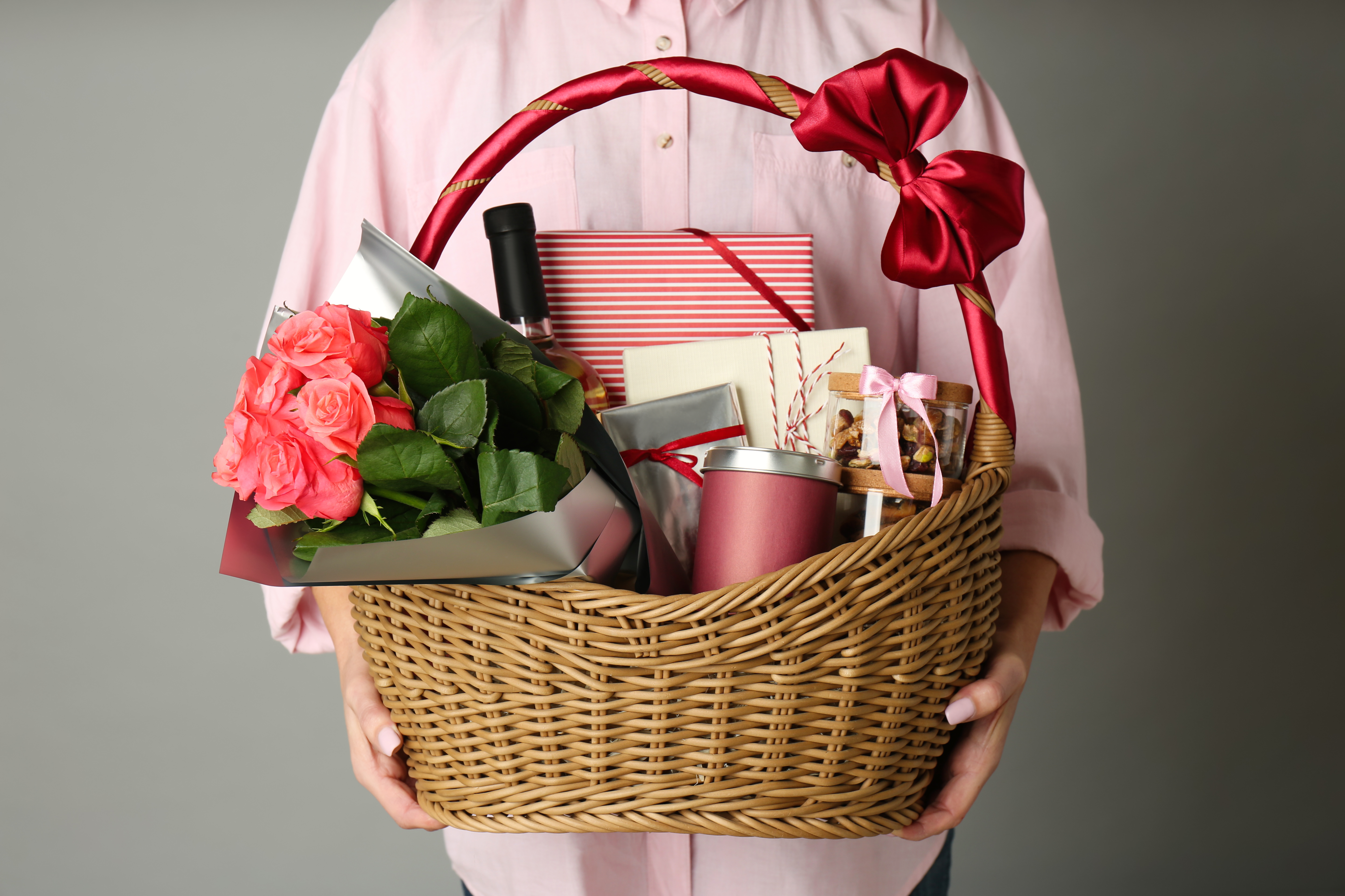 Personne tenant un panier en osier rempli de cadeaux | Source : Shutterstock