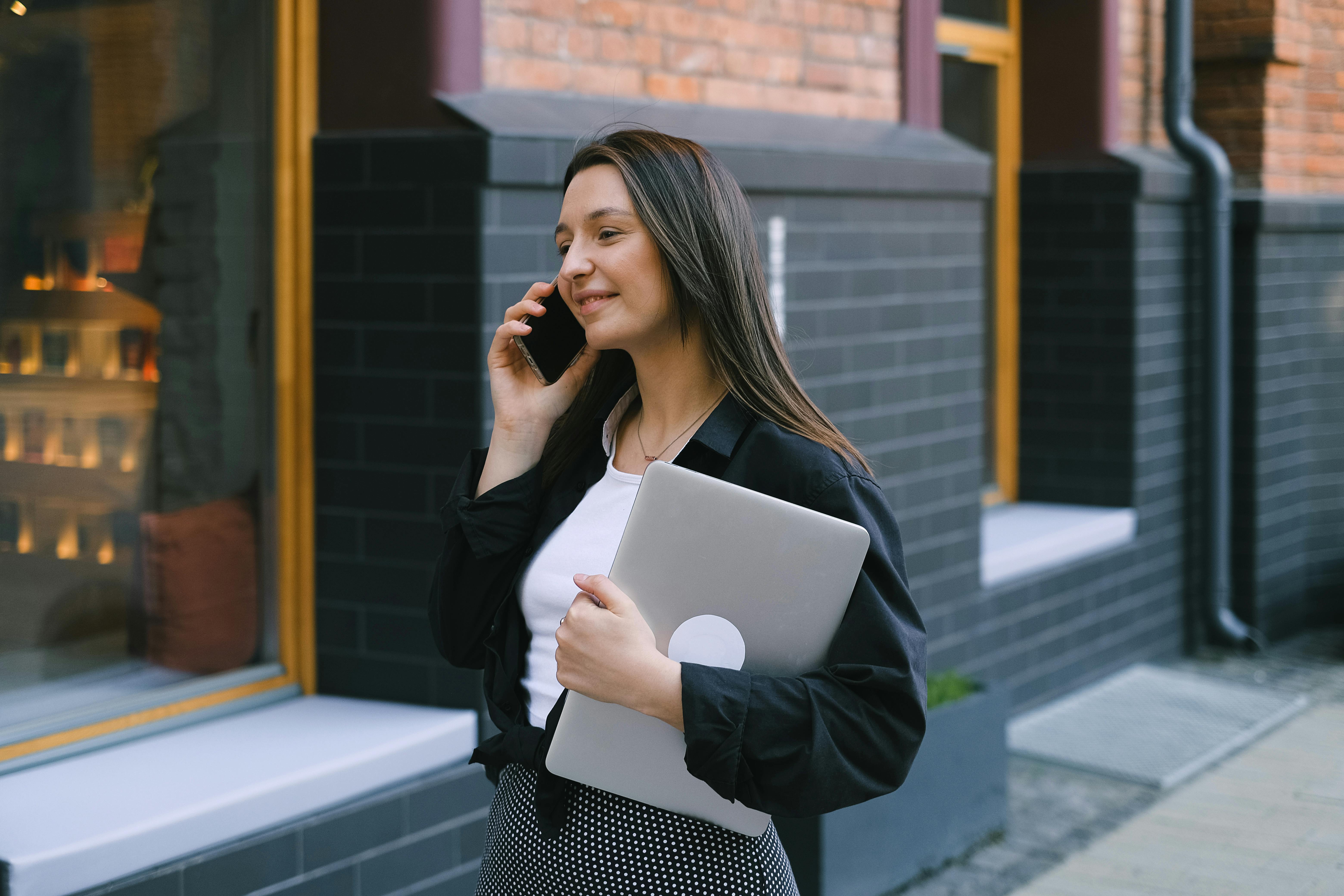 Femme marchant sur le trottoir tout en passant un appel téléphonique | Source : Pexels