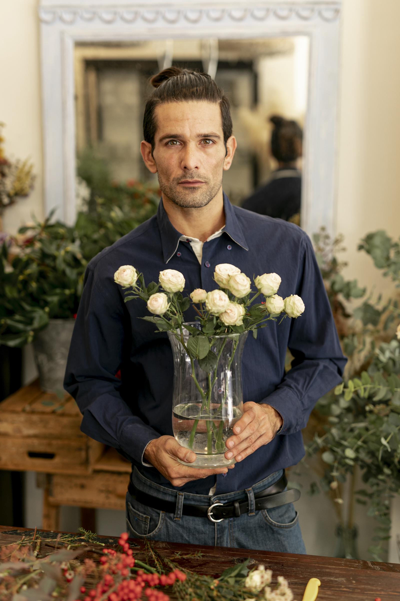 Un homme tenant des fleurs | Source : Freepik