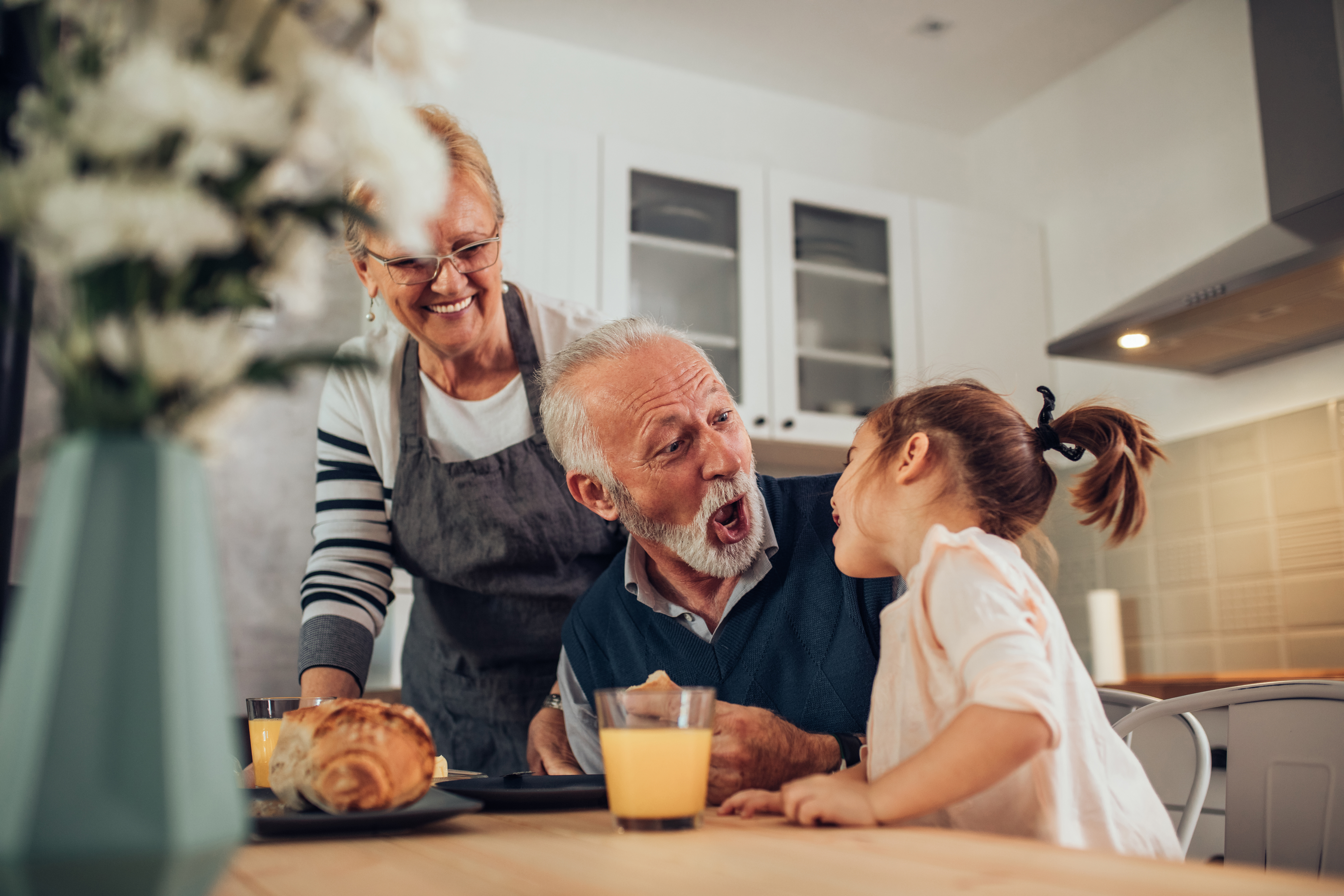 Des grands-parents profitent d'un repas avec leur petite-fille | Source : Shutterstock
