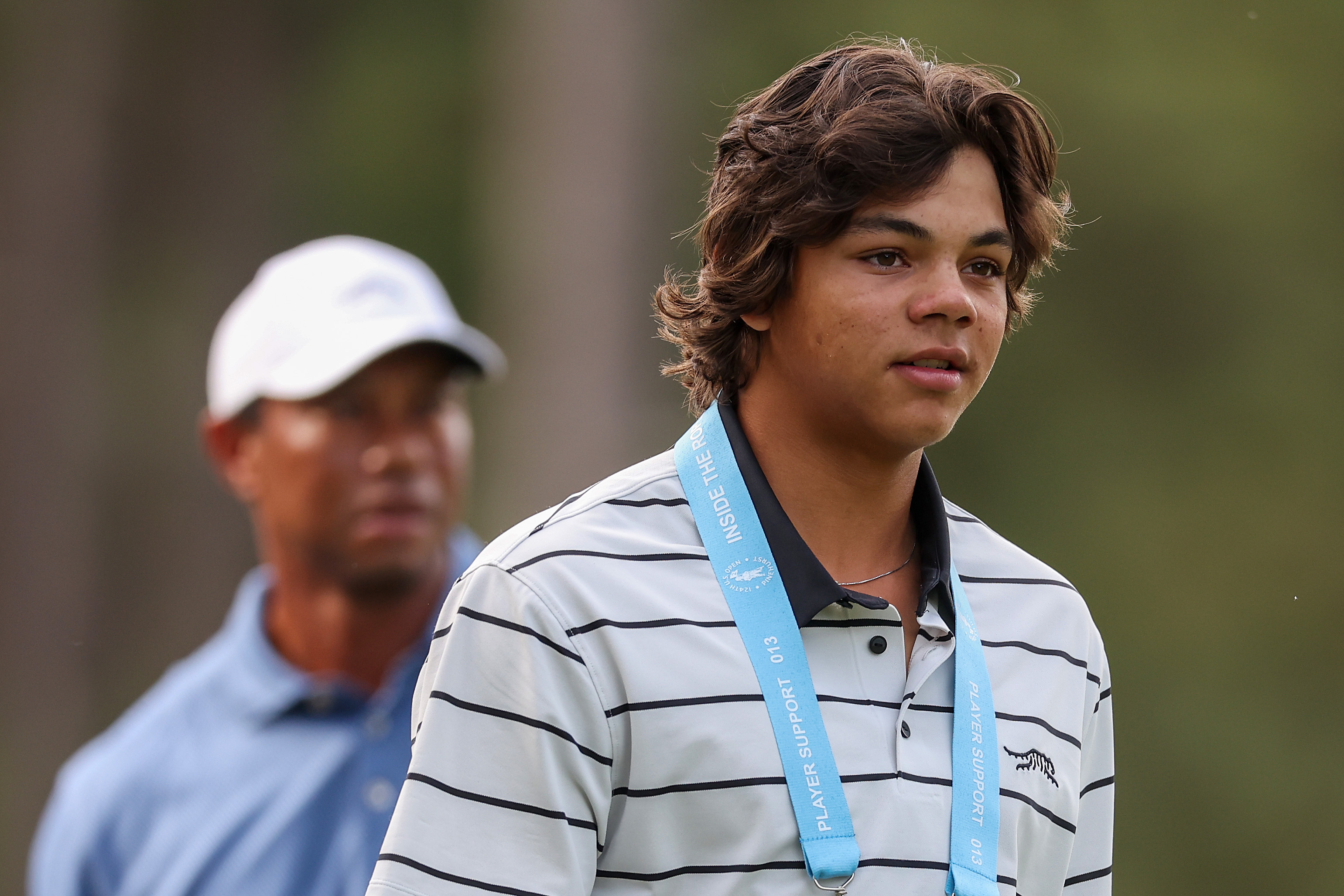 Charlie Woods a l'air sérieux devant son père Tiger Woods lors d'un tour d'entraînement avant l'U.S. Open à Pinehurst Resort en Caroline du Nord, le 10 juin 2024. | Source : Getty Images