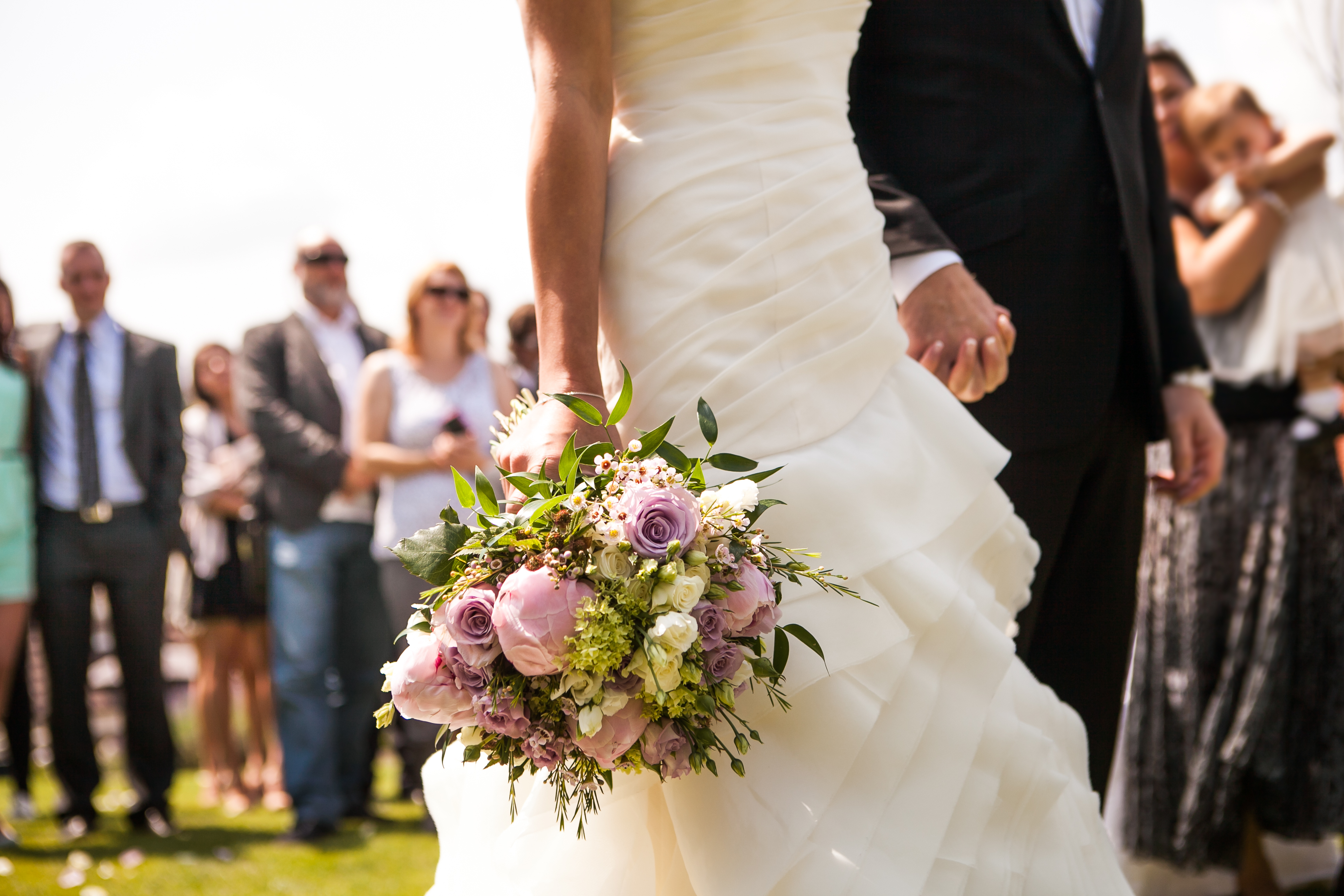 Une mariée et un marié se tenant par la main lors de leur mariage | Source : Shutterstock
