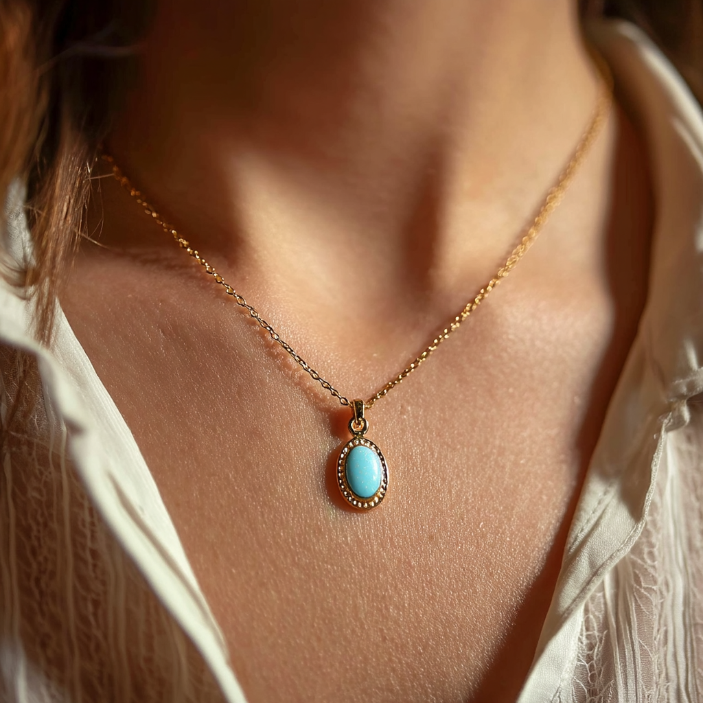 Gros plan sur une femme portant un pendentif en or avec une breloque en émail bleu pâle | Source : Midjourney