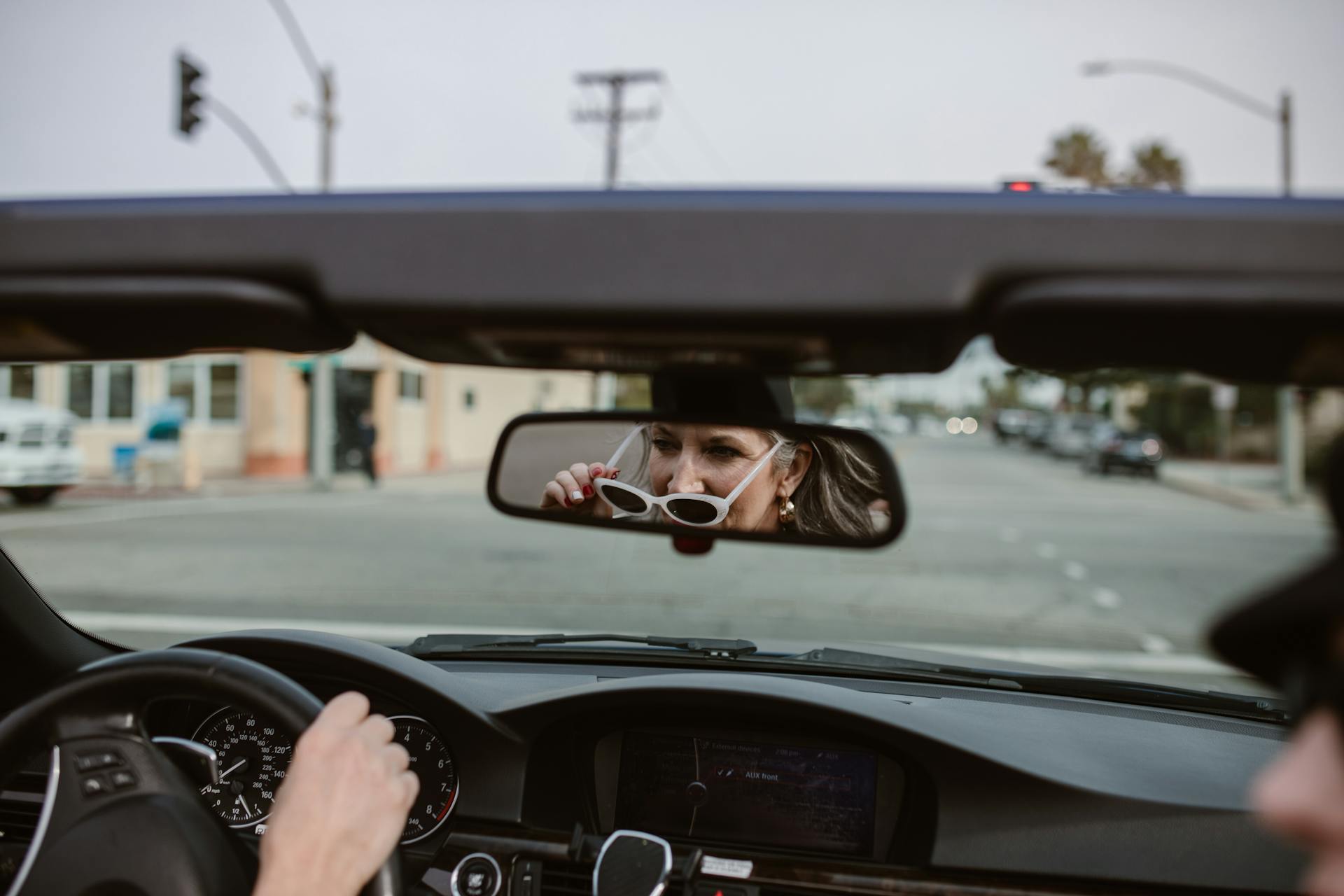 Reflet d'une femme d'âge moyen dans le rétroviseur au volant d'une voiture | Source : Pexels