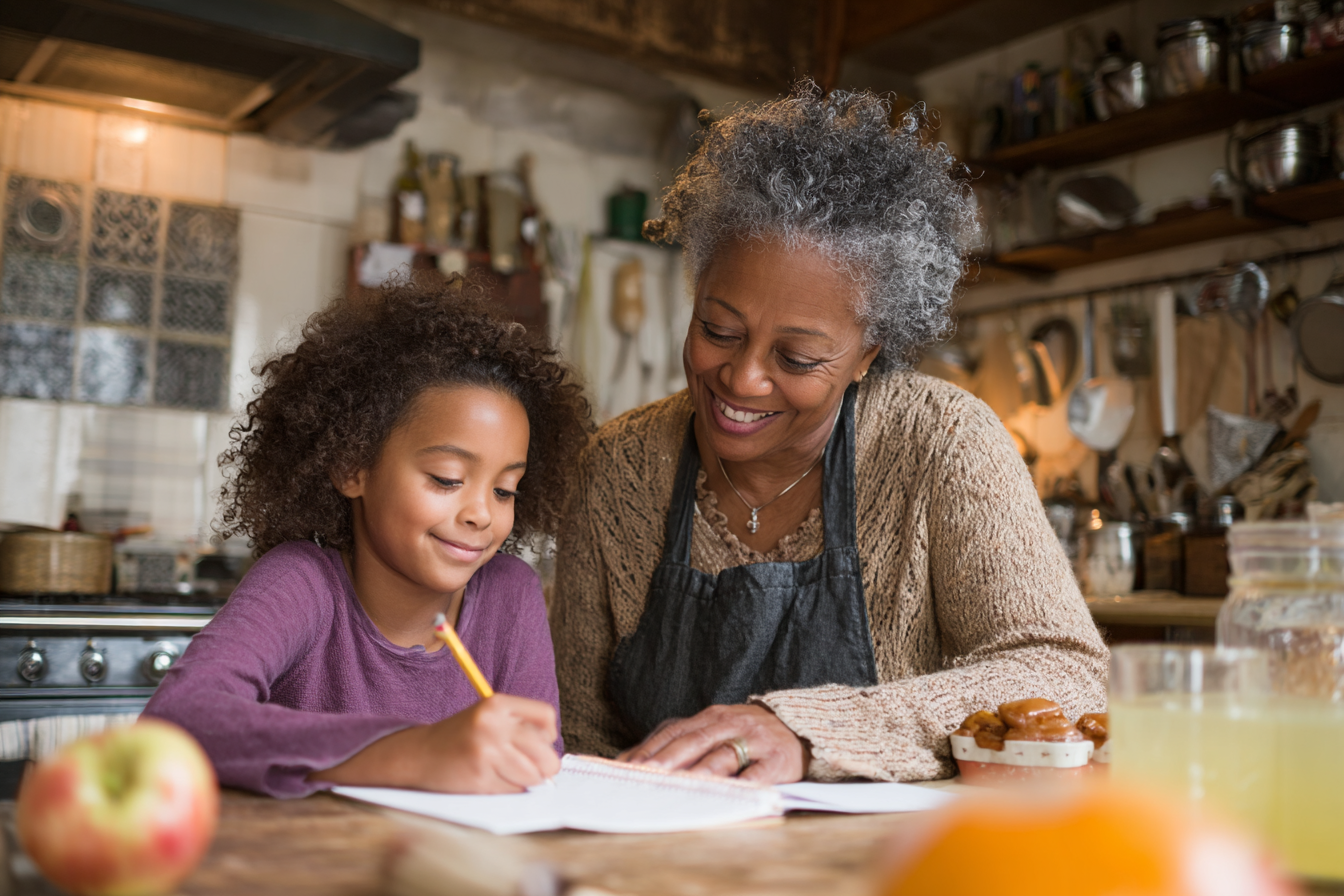 Une femme aidant sa petite-fille à faire ses devoirs | Source : Midjourney