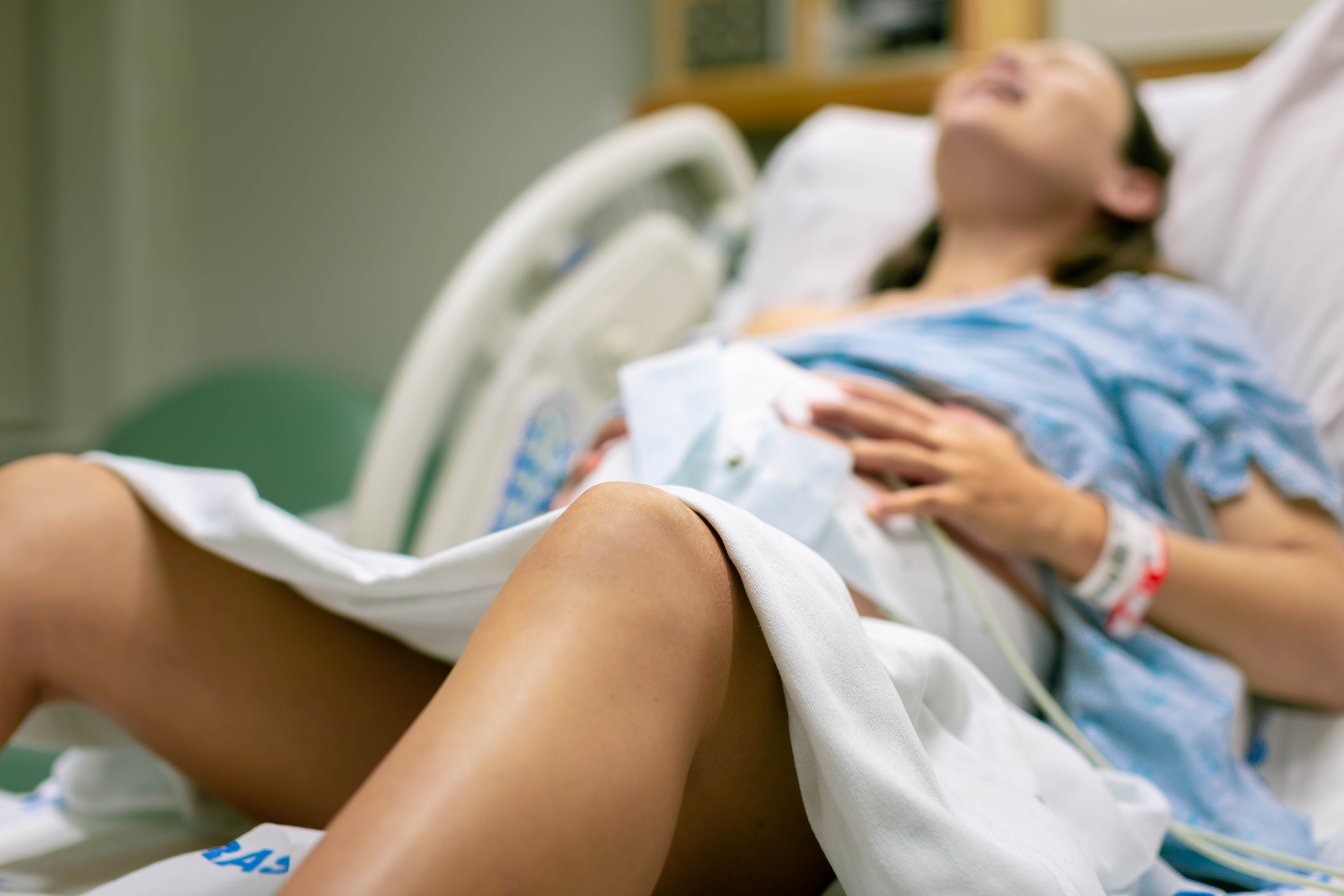 Photo d'une femme qui accouche, allongée sur un lit d'hôpital | Source : Shutterstock