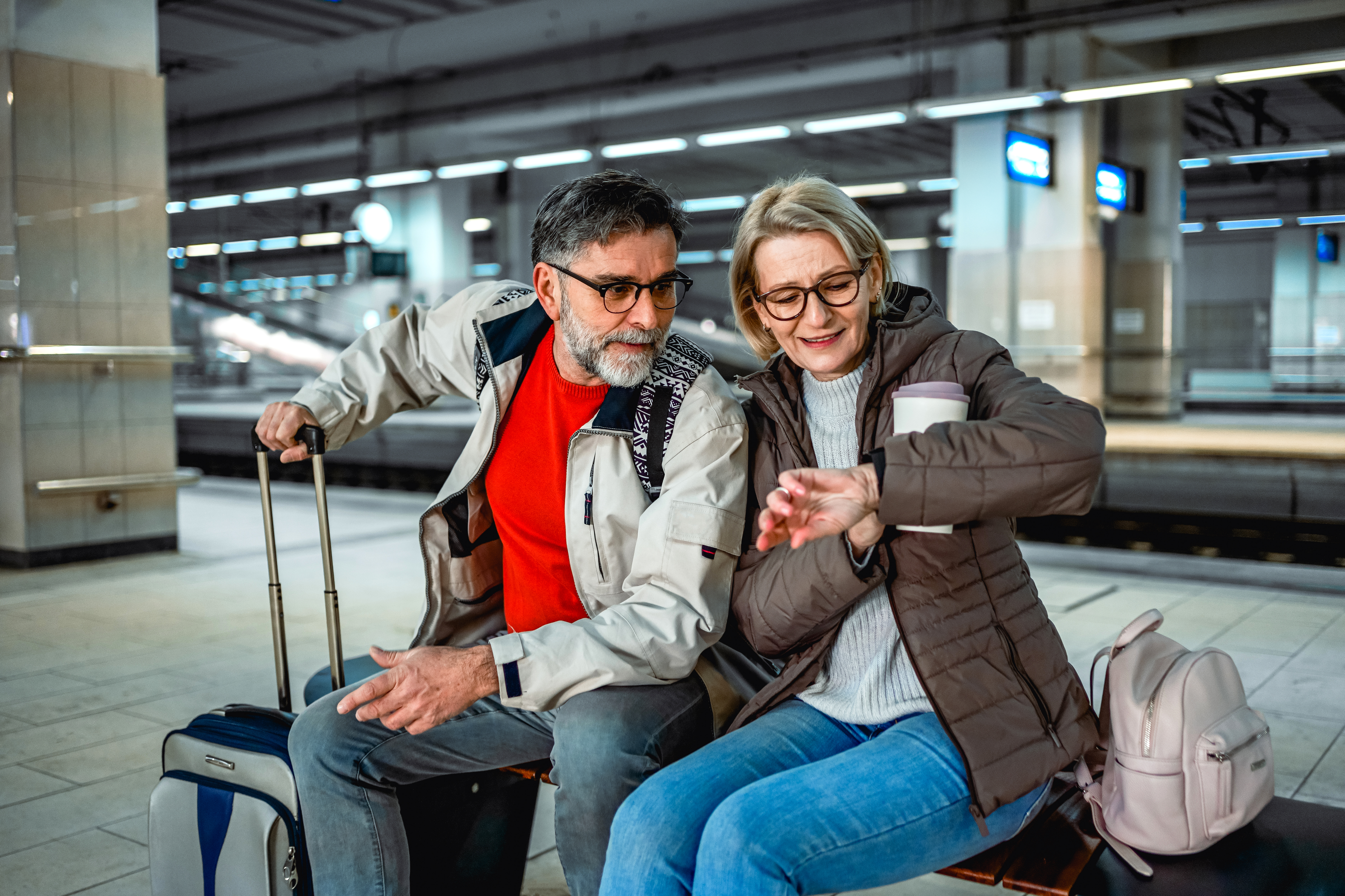 Un vieux couple regarde une montre-bracelet dans un aéroport : Getty Images