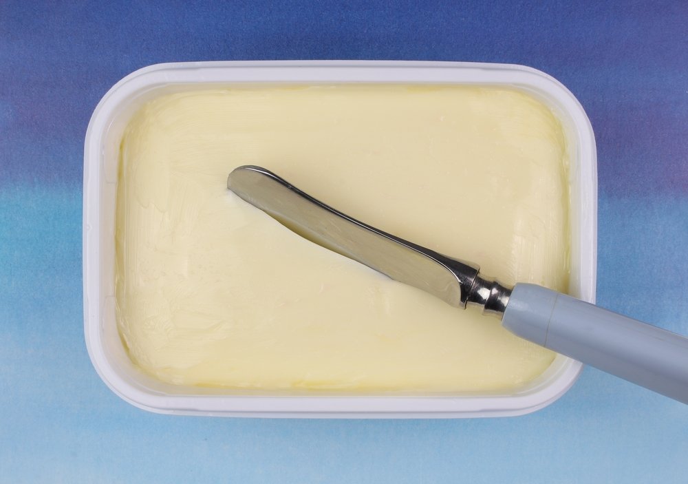Un pot de margarine avec un couteau dedans. | Shutterstock