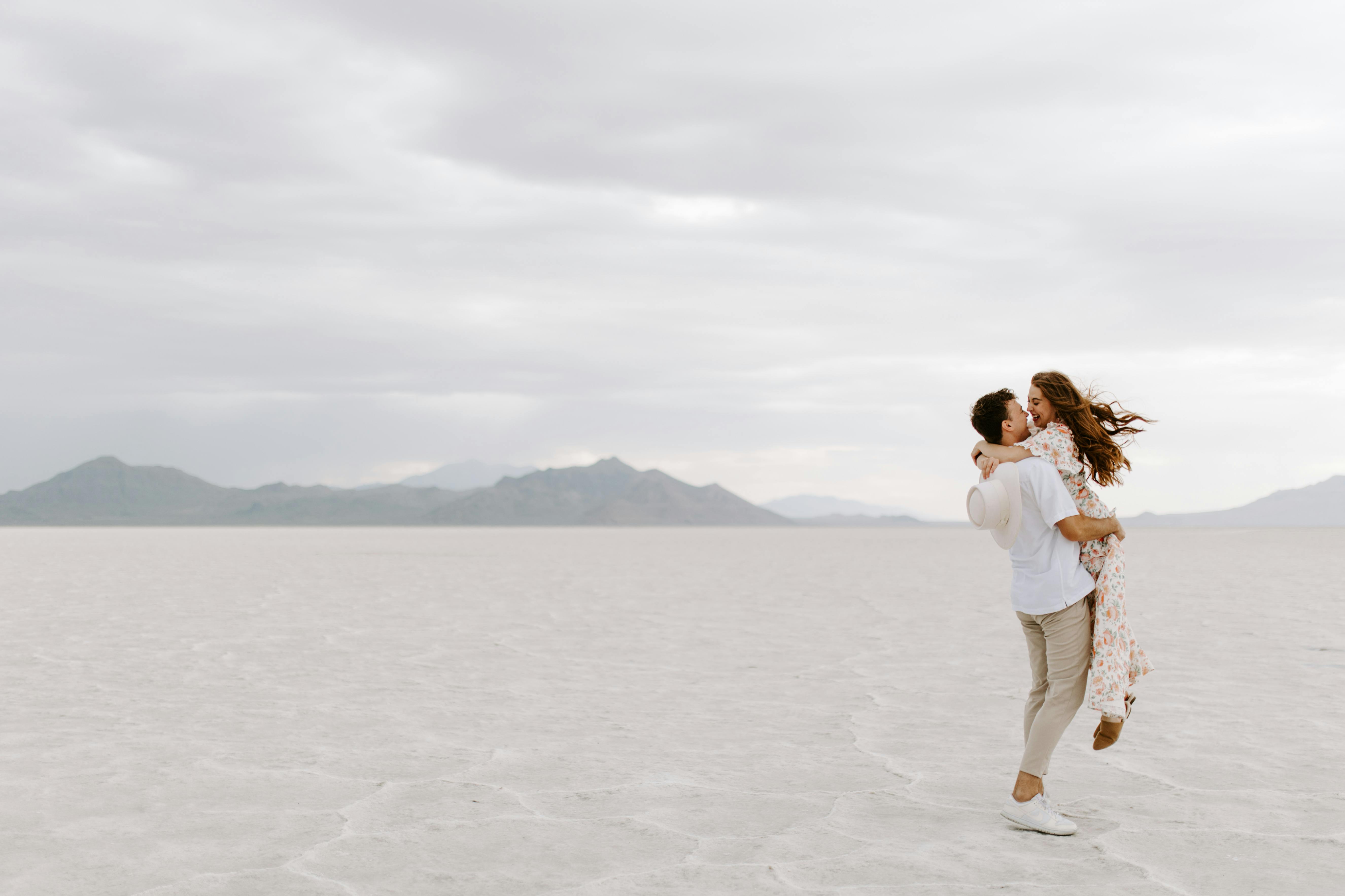 Un couple s'embrassant dans un désert de sable blanc | Source : Pexels