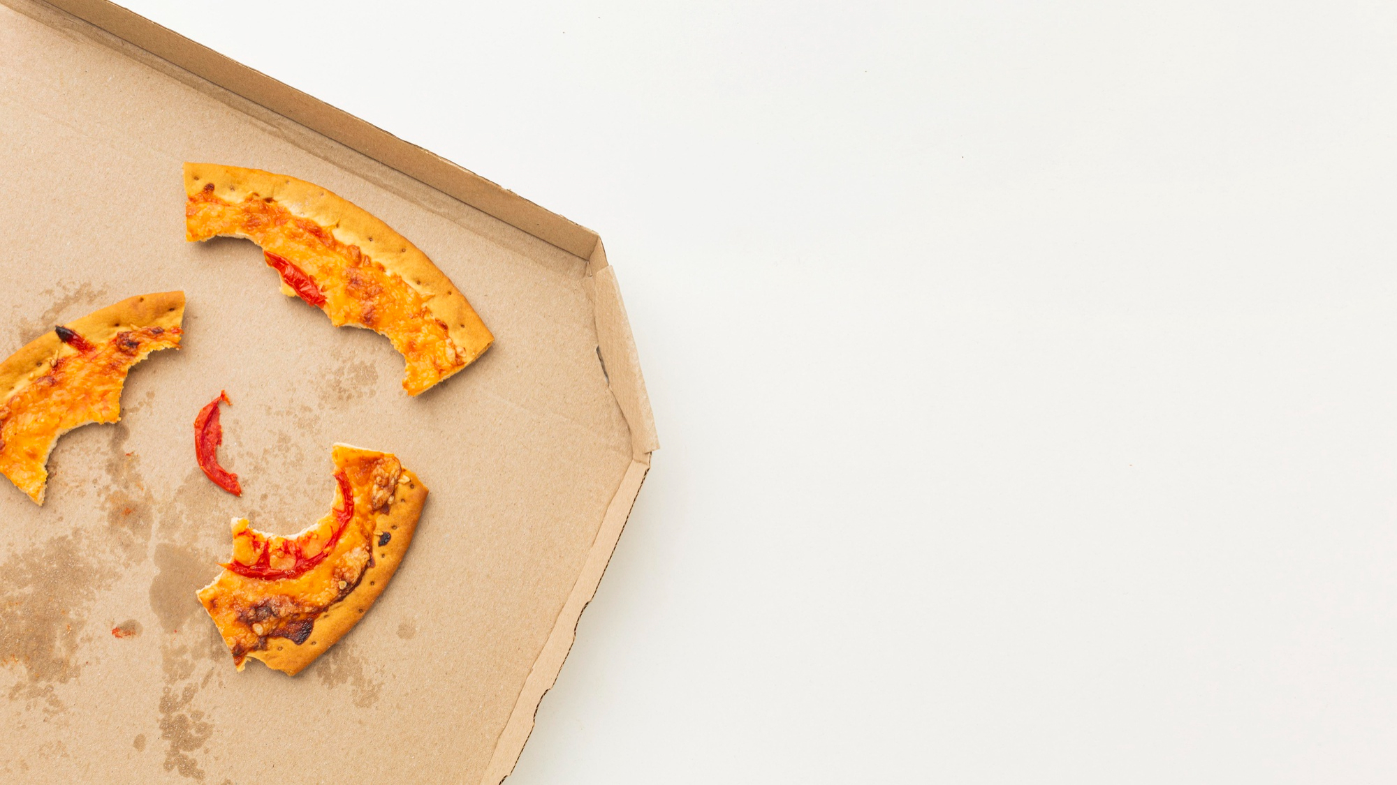 Des restes de croûtes de pizza dans une boîte | Source : Freepik
