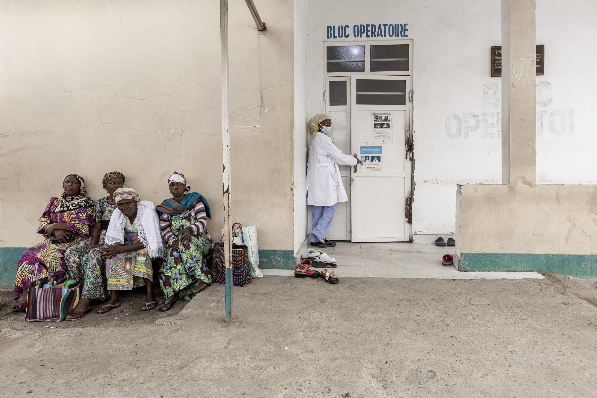 Une infirmière entre dans la salle d'opération d'un hôpital de la République démocratique du Congo alors que des femmes attendent à l'extérieur | Source : Getty Images