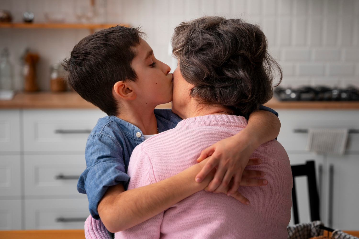 Un petit garçon embrassant sa grand-mère sur la joue | Source : Freepik