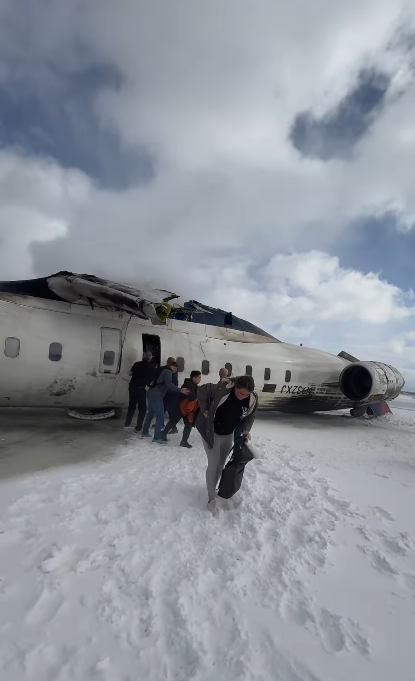 De la fumée s'échappe de l'avion alors que d'autres passagers en sortent et s'éloignent sur le sol enneigé | Source : Instagram.com/eggxit