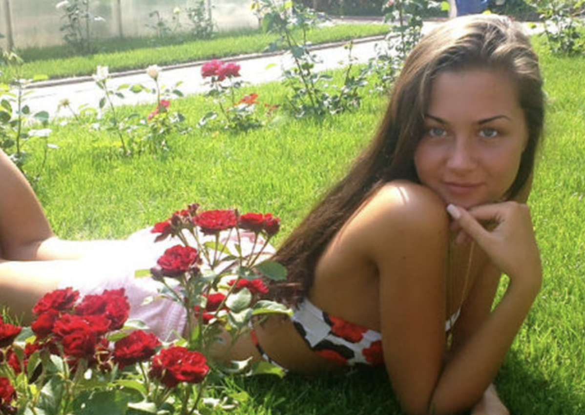 La jeune fille est allongée dans le parterre de fleurs | Source : Shutterstock