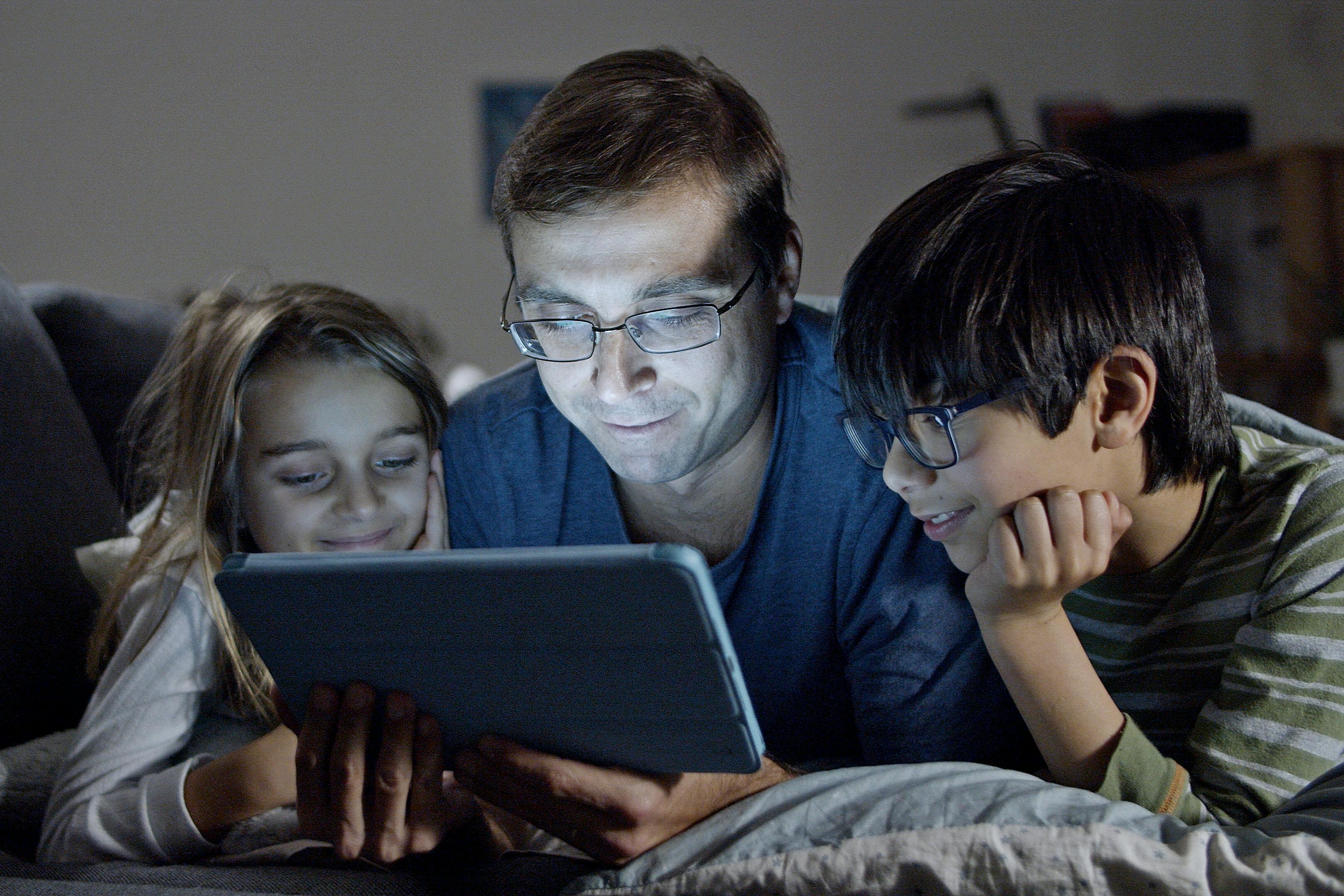 Un homme et ses enfants regardant une tablette | Source : Pexels