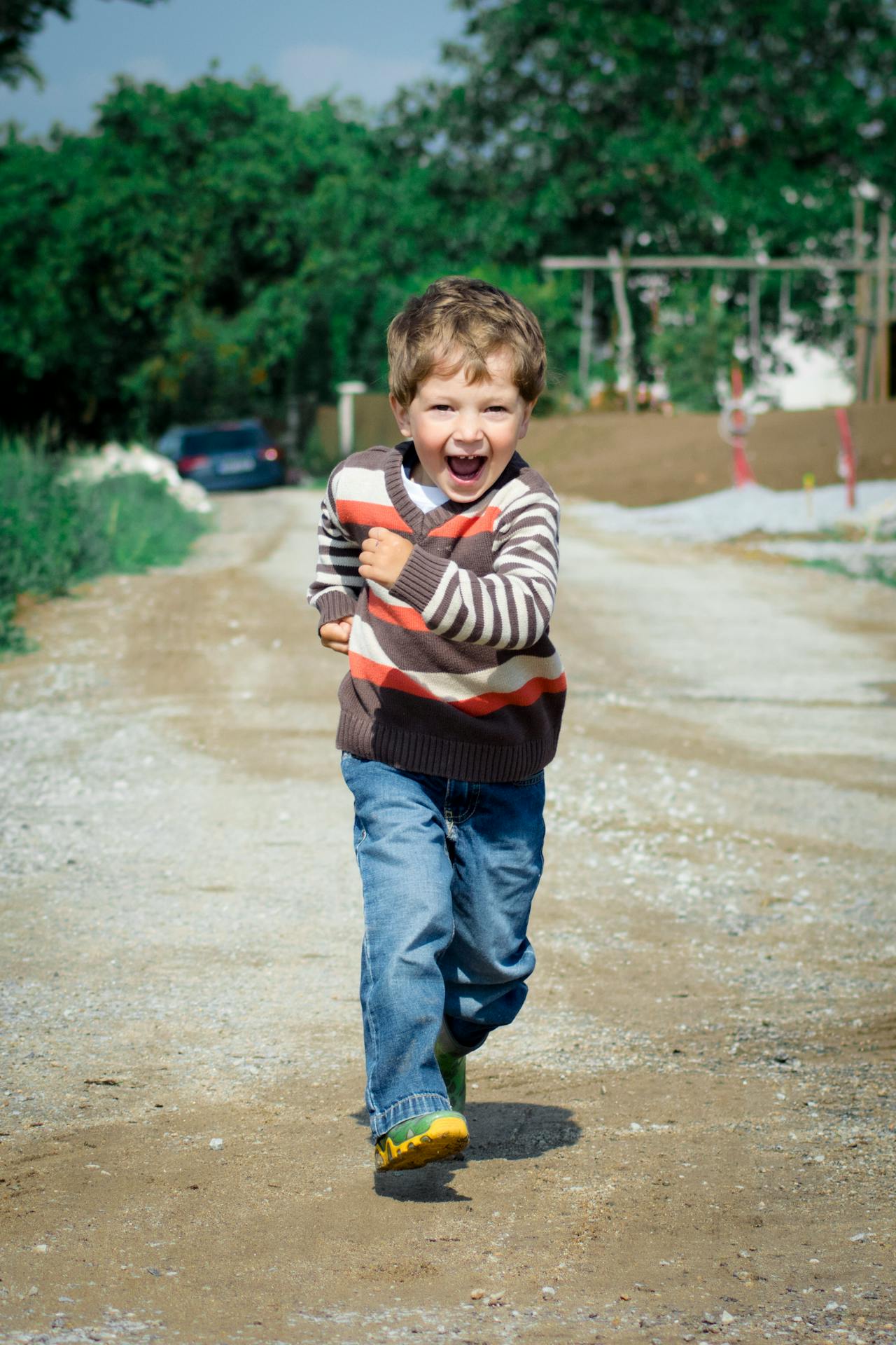 Un petit garçon heureux qui marche sur la route | Source : Pexels