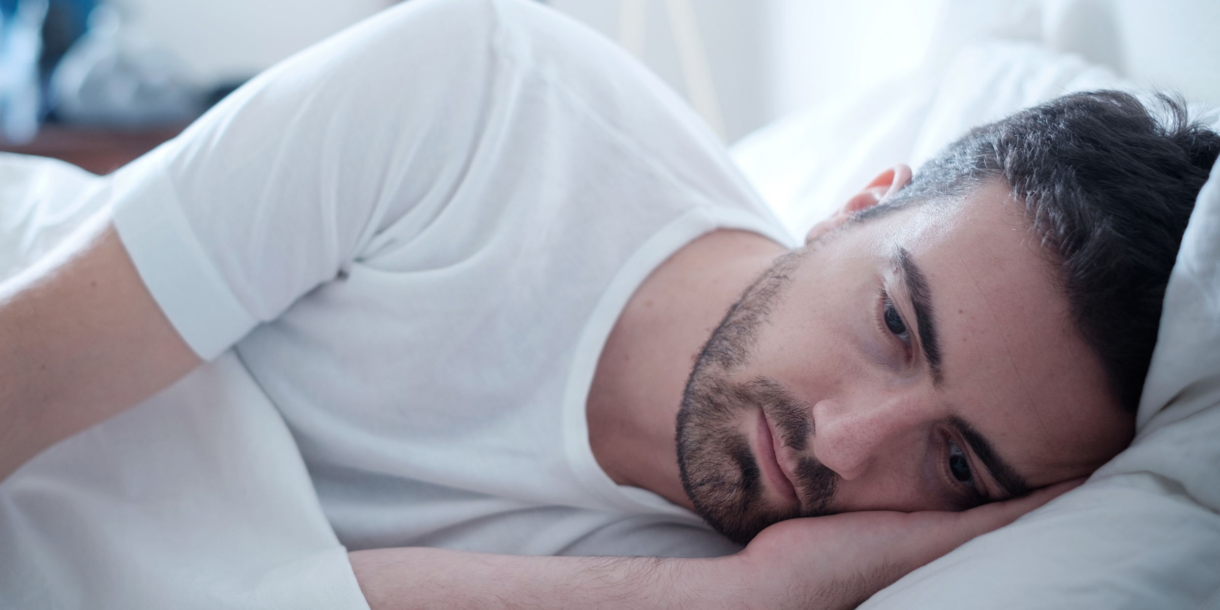 Un homme allongé dans son lit | Source : Shutterstock