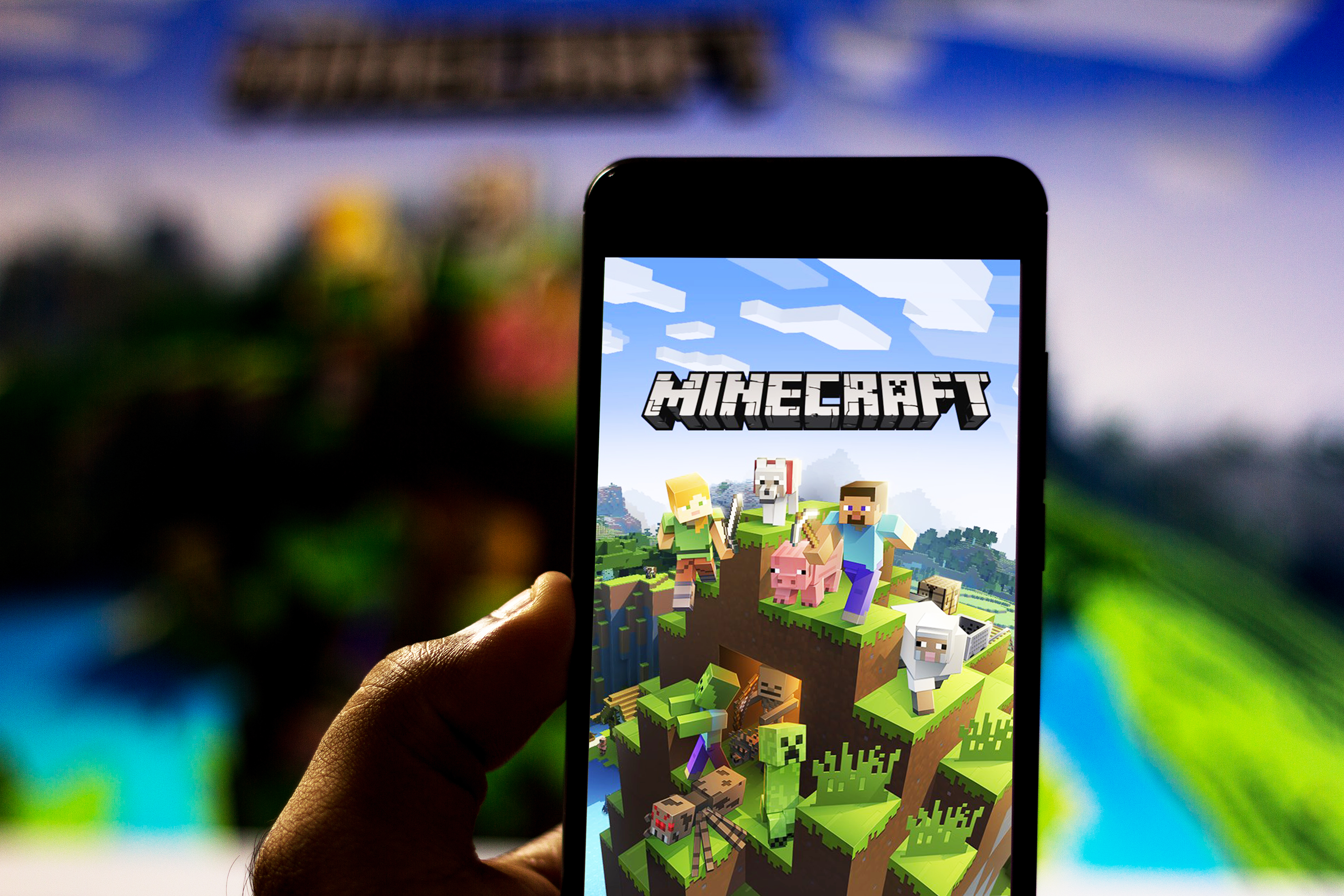 Une image d'une personne tenant un téléphone avec Minecraft dessus│Source : Shutterstock.