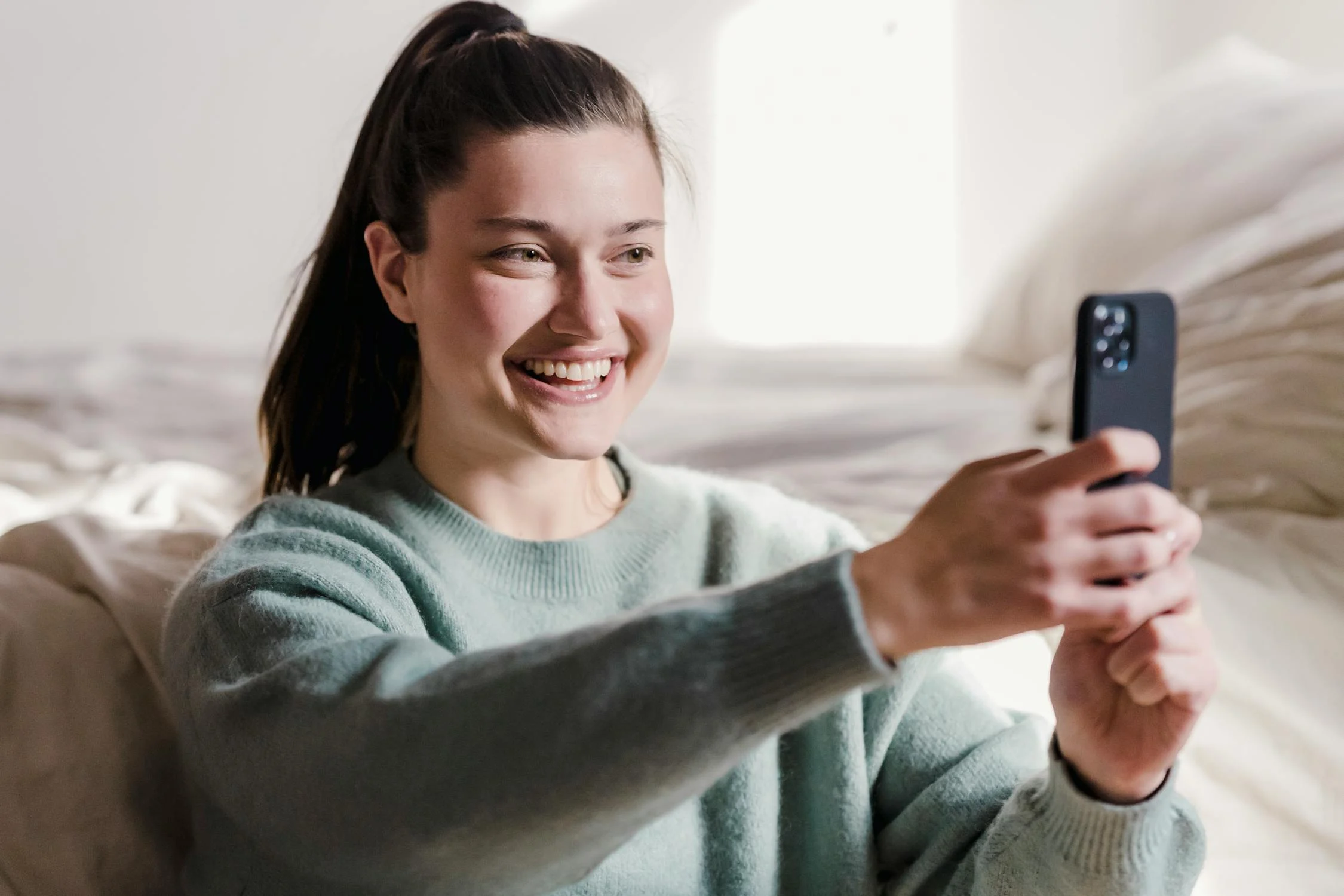 Une femme prenant une photo sur son téléphone | Source : Pexels