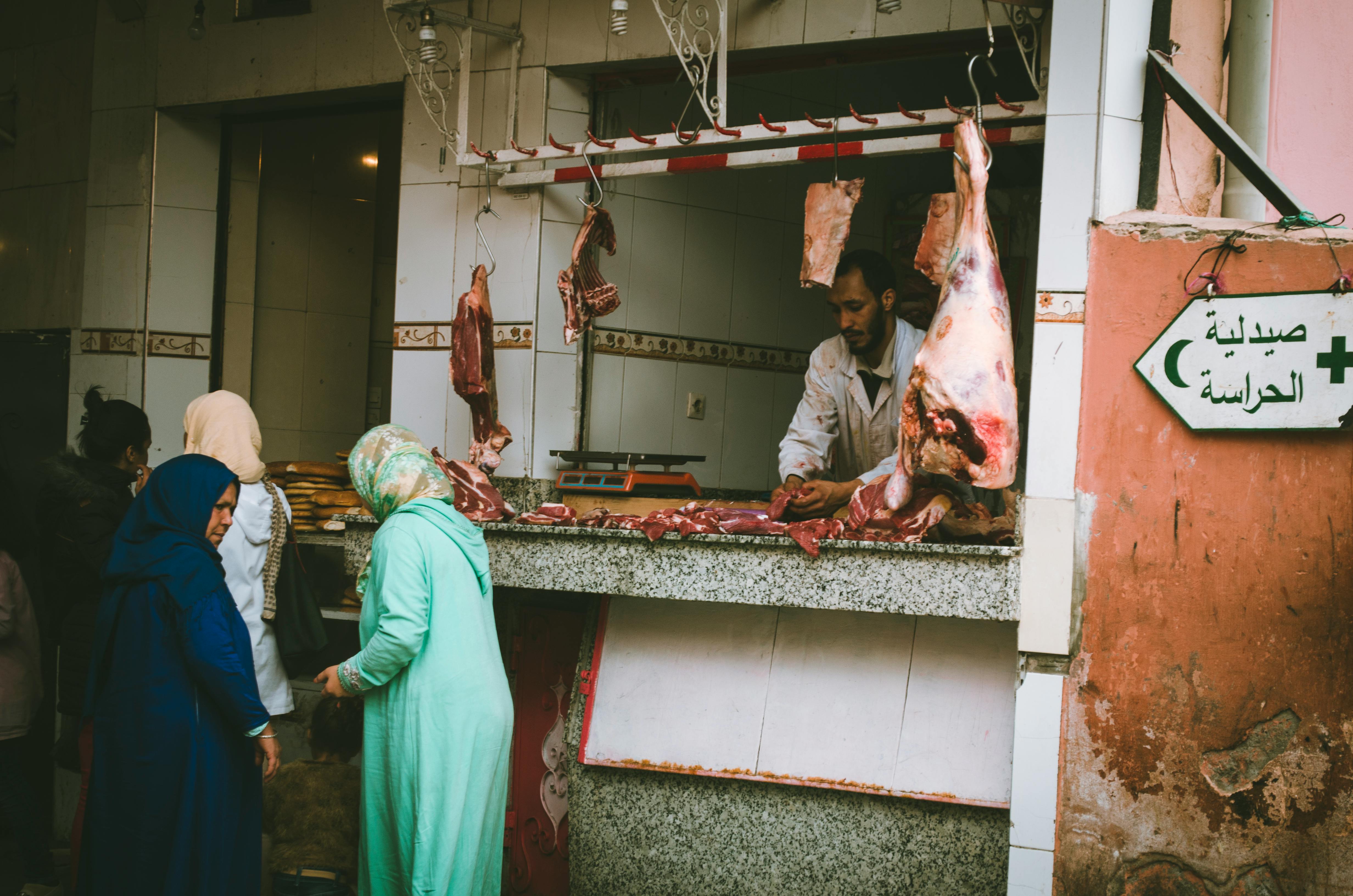 Des gens achètent de la viande dans une boucherie | Source : Pexels