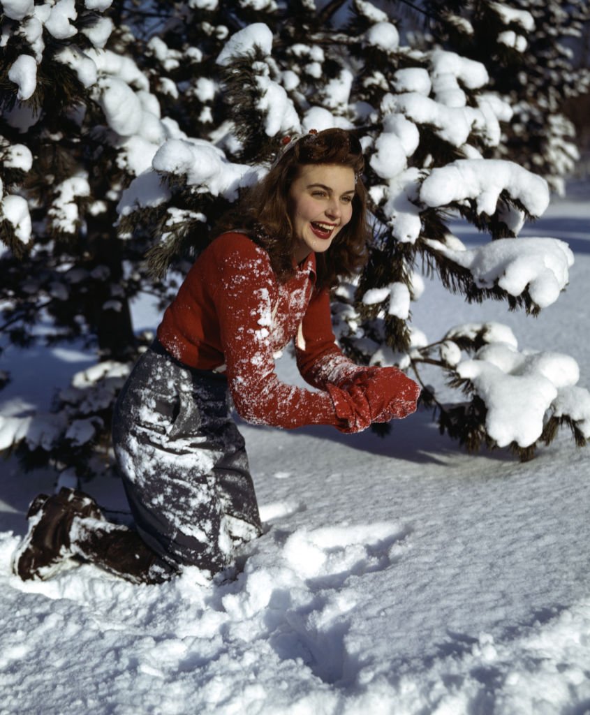 Une femme qui joue dans la neige| photo : Getty Images