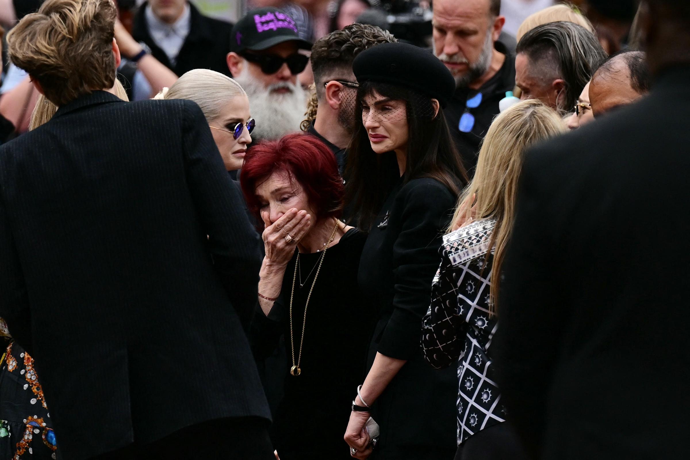 Sharon, Kelly et Aimee Osbourne réagissent aux hommages laissés sur le banc du pont Black Sabbath lors du cortège funèbre d'Ozzy à Birmingham le 30 juillet 2025 | Source : Getty Images