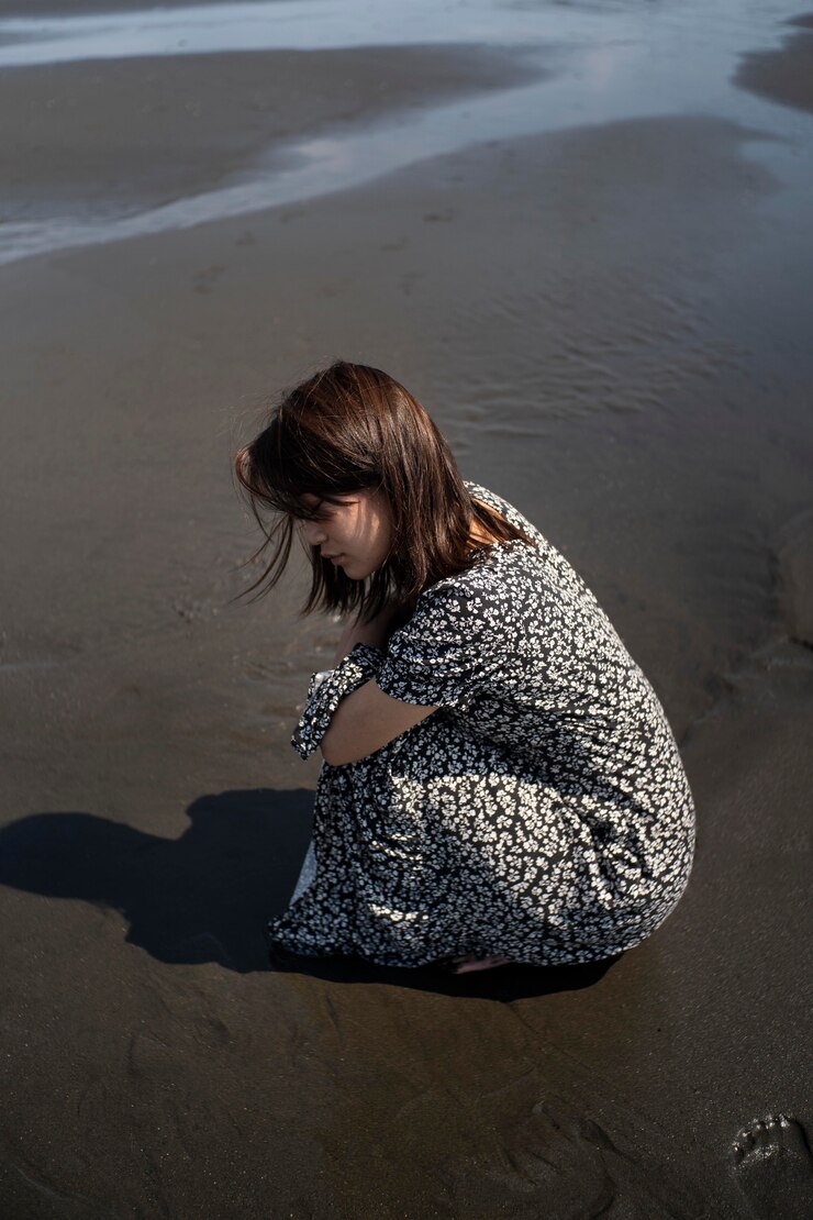 Une femme triste sur une plage | Source : Freepik