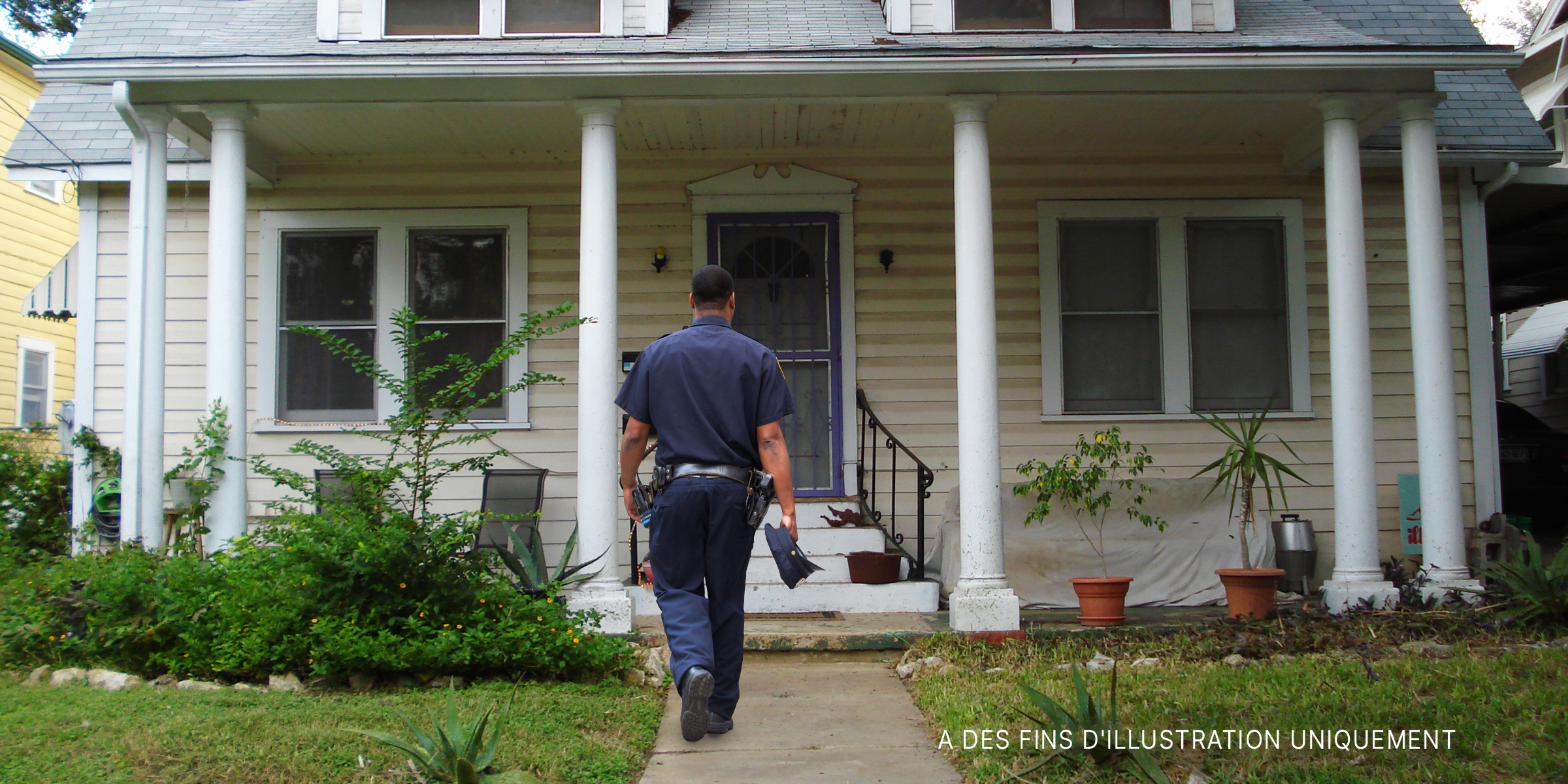 Un policier qui marche vers une maison. | Source : Flickr / St_A_Sh (CC BY 2.0) & Shutterstock Flickr / St_A_Sh (CC BY 2.0) & Shutterstock
