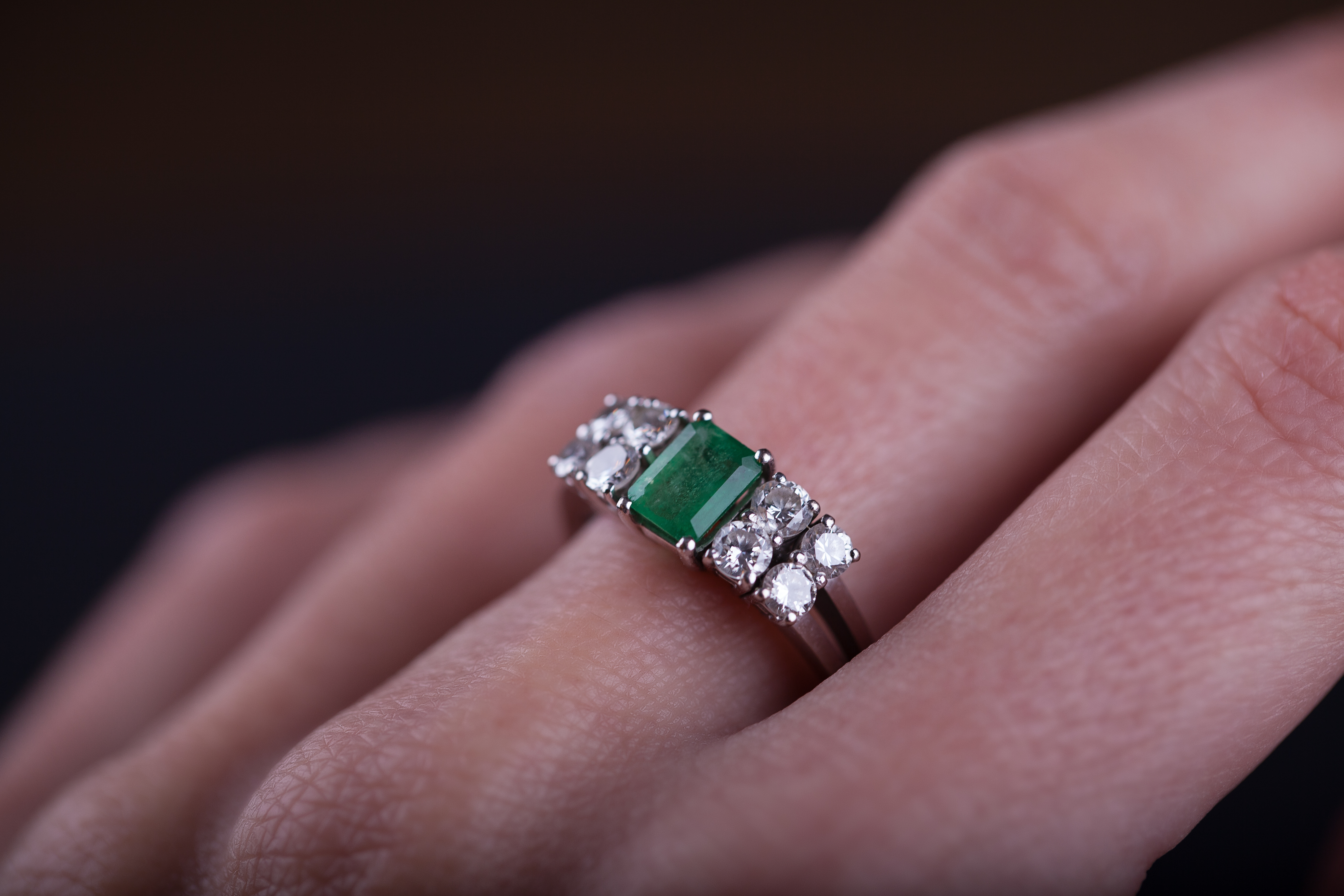 Une bague en émeraude et en diamant sur un doigt Source : Getty Images