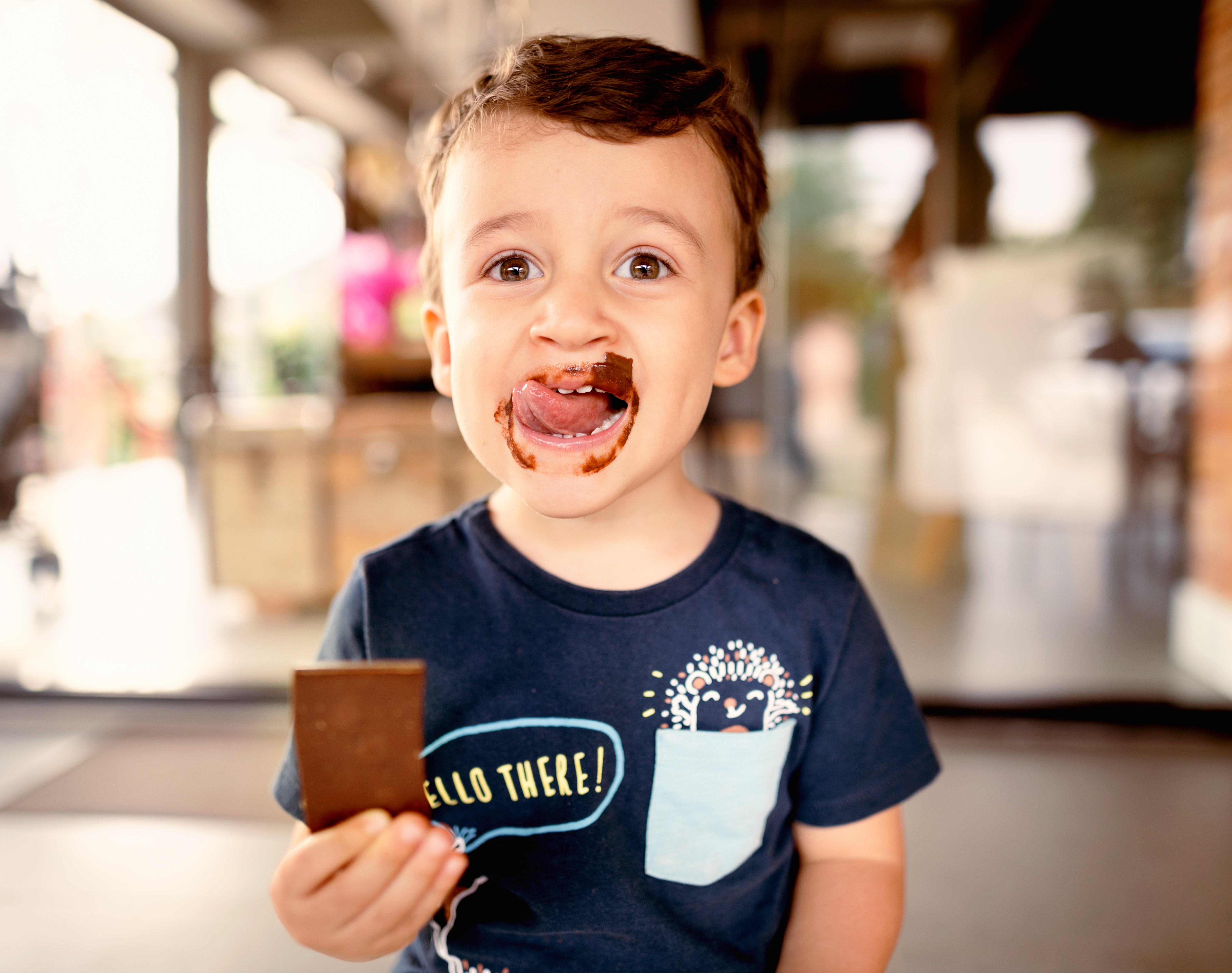 Petit garçon souriant léchant du chocolat en désordre sur son visage | Source : Getty Images